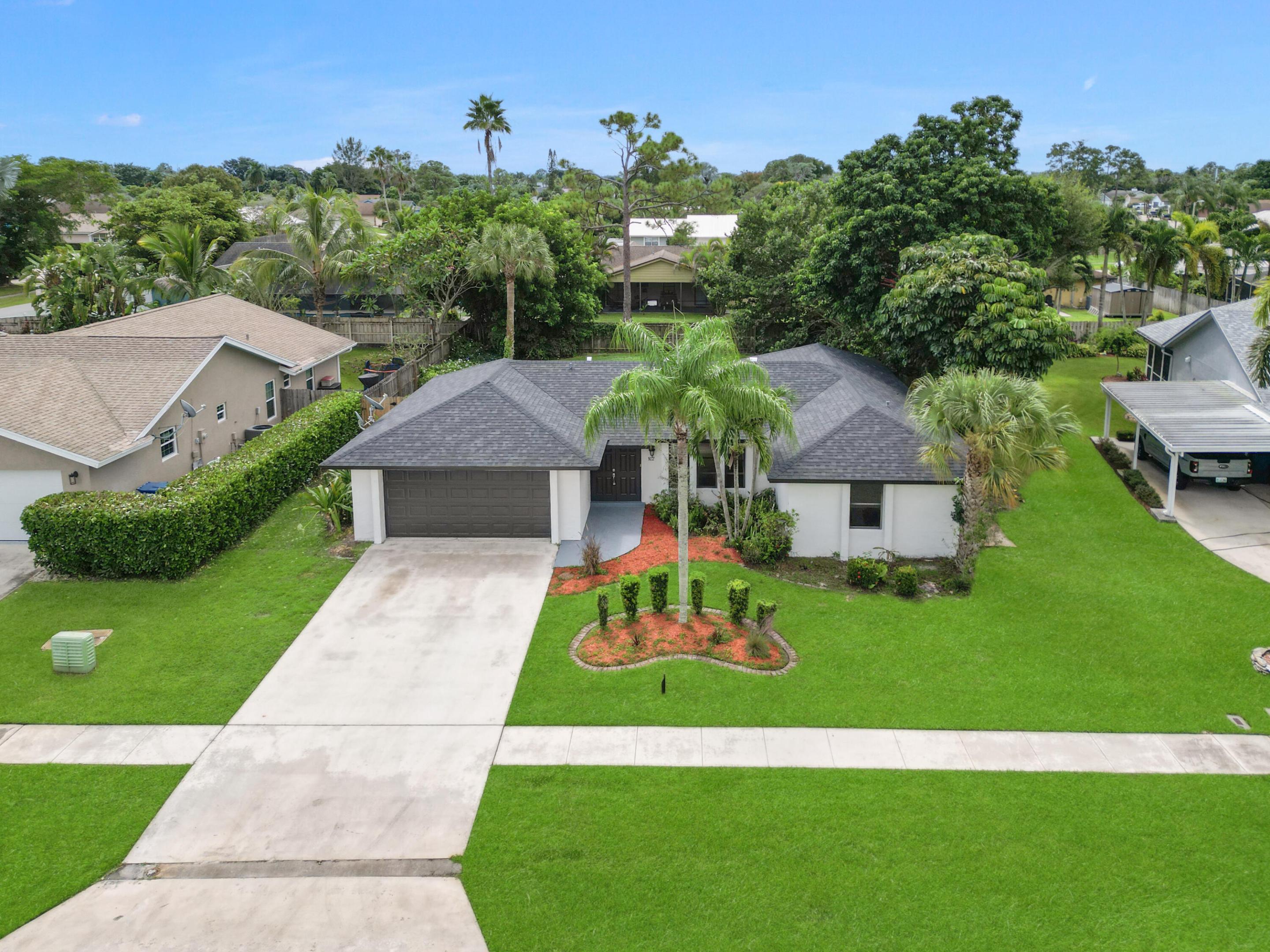 Single-story residence featuring a dark shingle roof, attached garage, and a concrete driveway