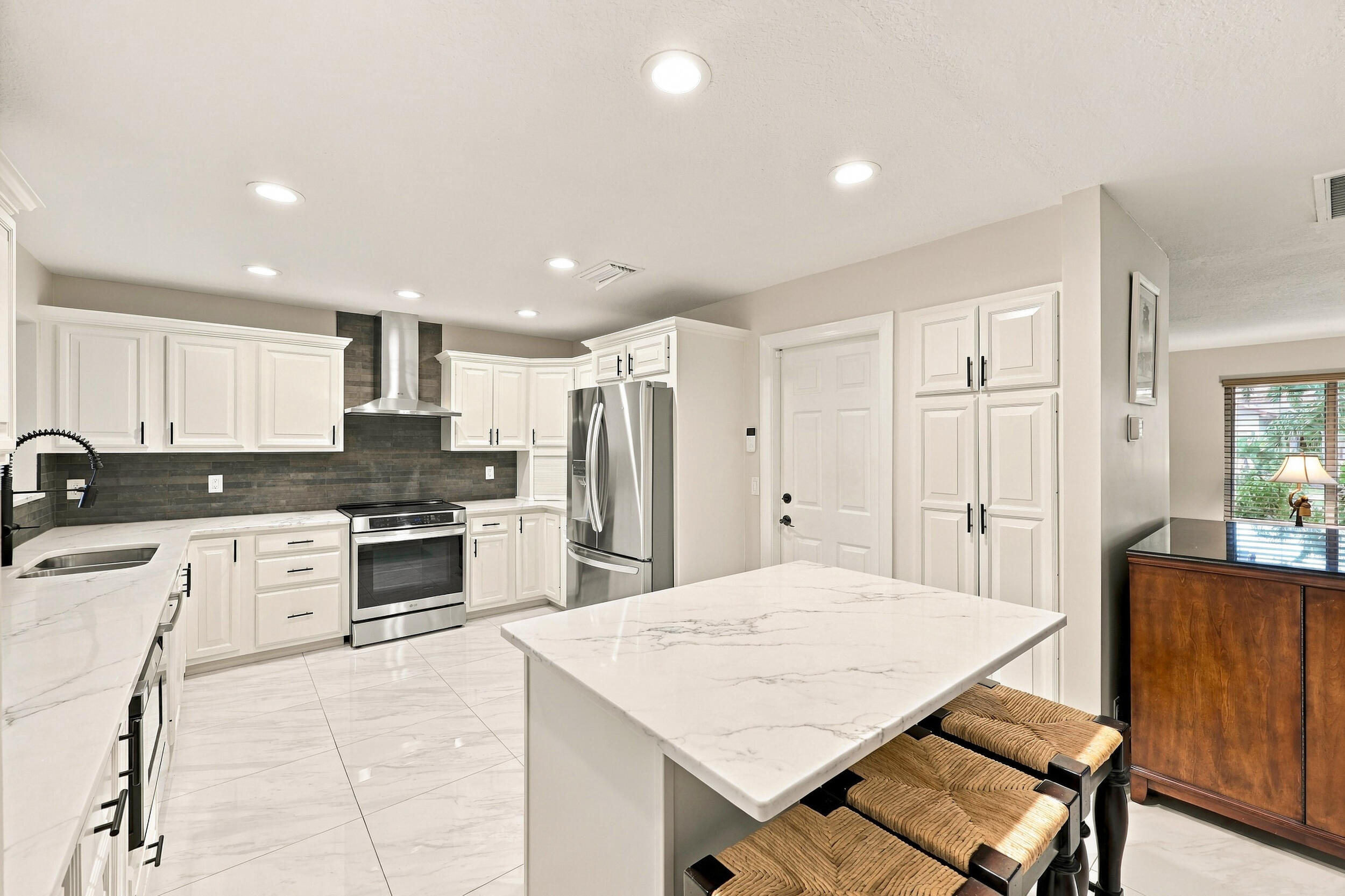 The impeccably upgraded kitchen offers white cabinetry, quartz countertops, stainless steel appliances, and a beautiful charcoal backsplash. There is tons of storage and counter space for even the most discerning chef.