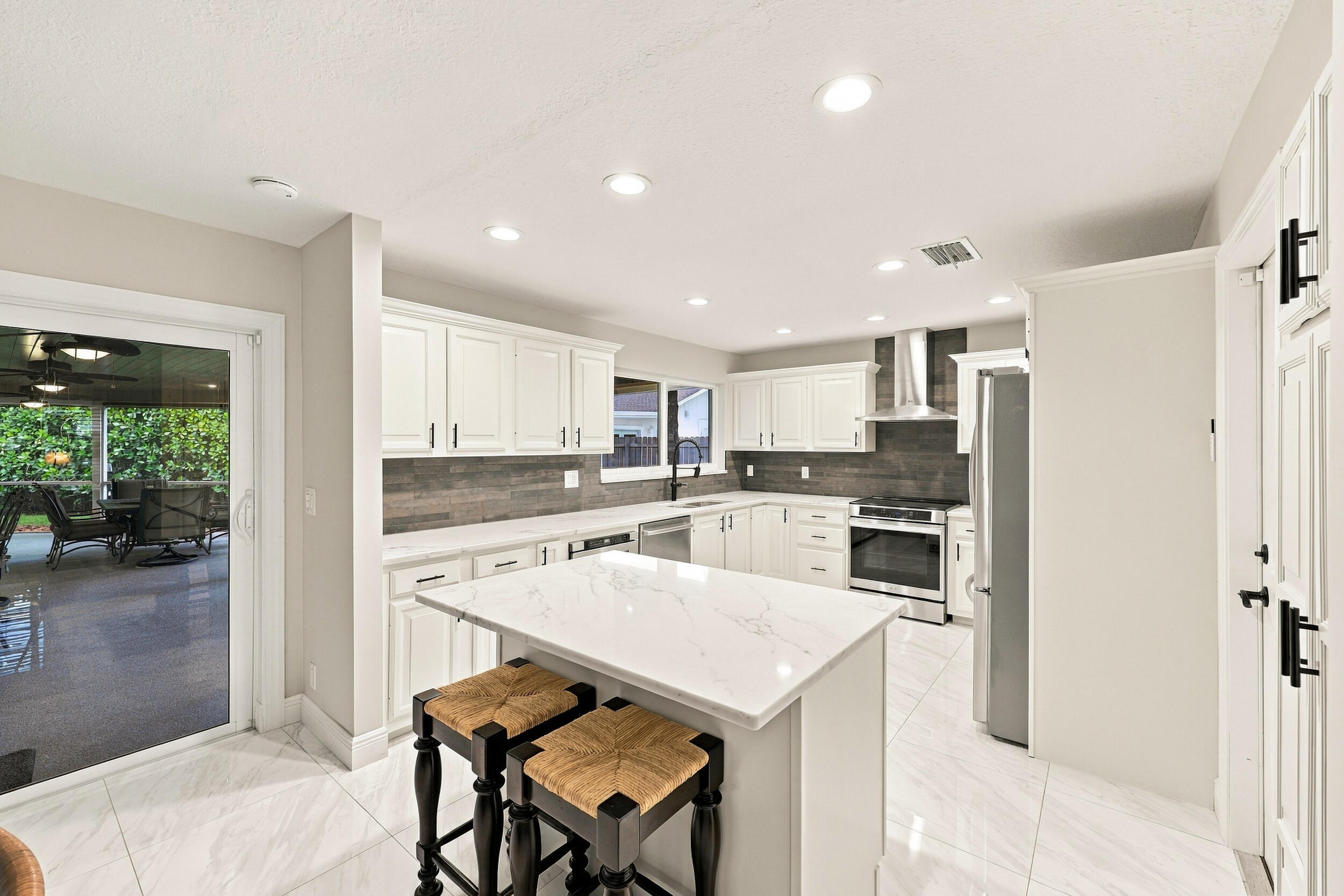The dining space and eat-in kitchen are highlighted by new floors and a beautifully updated kitchen with quartz countertops and stainless steel appliances. Views of the resort-style pool can be seen from all areas of the house.