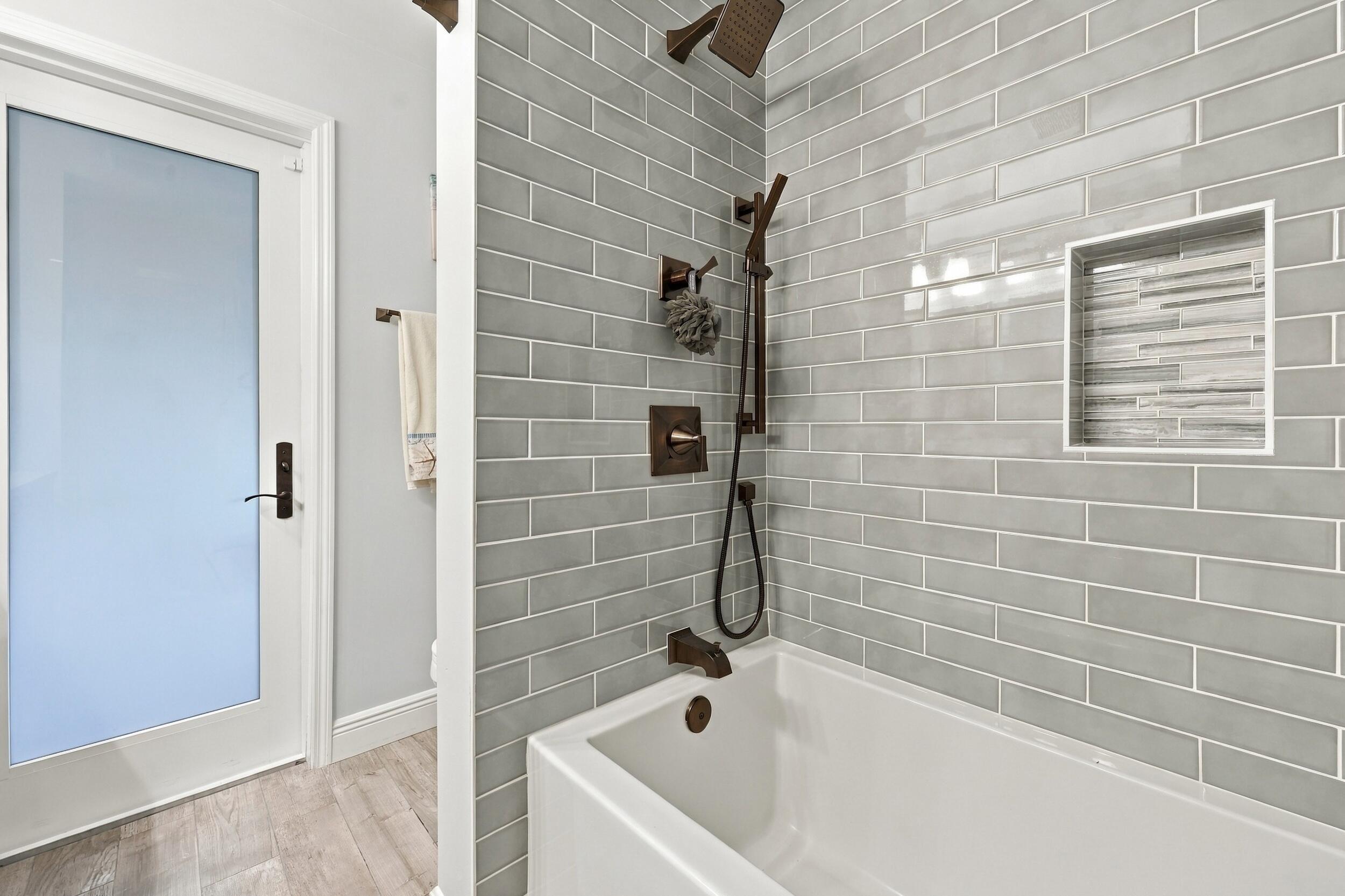 Bathroom 3 is a fully updated cabana bathroom with a new vanity, countertops, tile, and a tub and shower. Your guests will access it while spending days and evenings in the most beautiful backyard in Delray Beach.