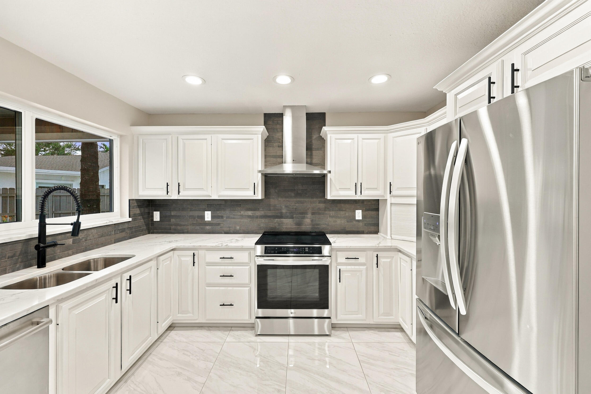 The impeccably upgraded kitchen offers white cabinetry, quartz countertops, stainless steel appliances, and a beautiful charcoal backsplash. There is tons of storage and counter space for even the most discerning chef.