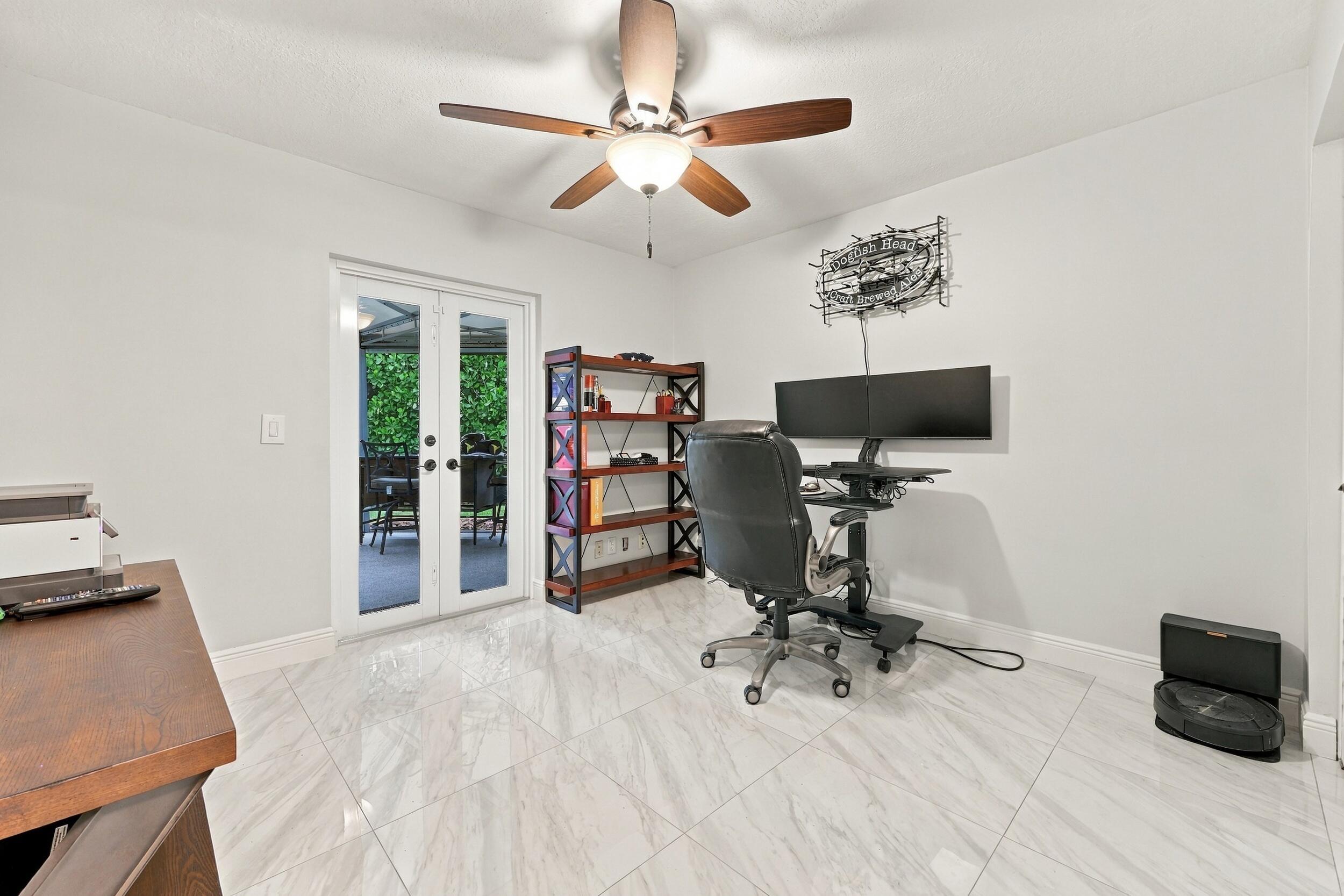 Guest bedroom 2 is spacious, with an abundance of natural light coming through the hurricane-impact French doors that lead to the 900-square-foot covered and screened-in patio.