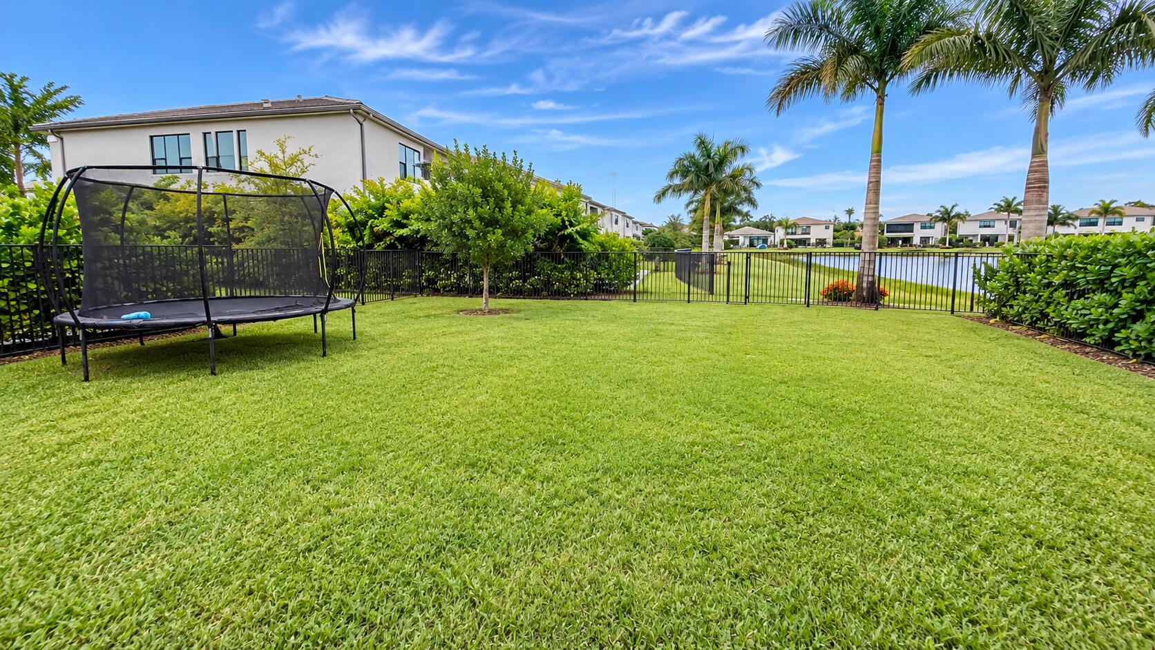 Sunny Waterfront Backyard with Trampolin