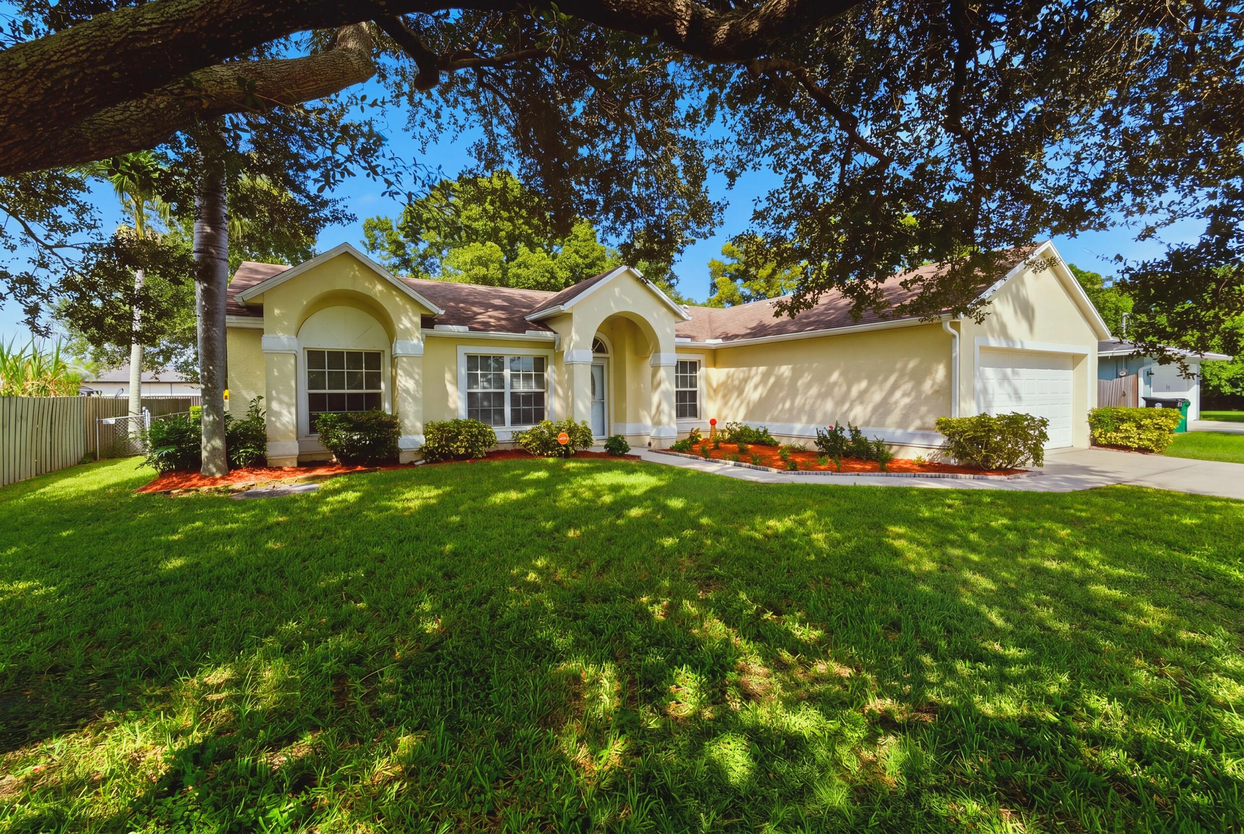 Single-story residence featuring a stucco exterior, arched covered entryway, multi-pane windows, and an attached two-car garage