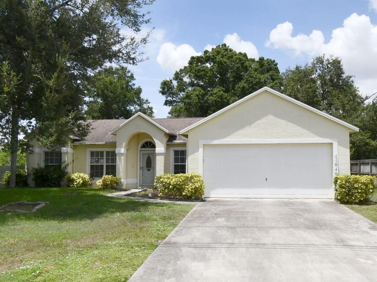 Single-story residence featuring a stucco exterior, arched covered entryway, multi-pane windows, and an attached two-car garage