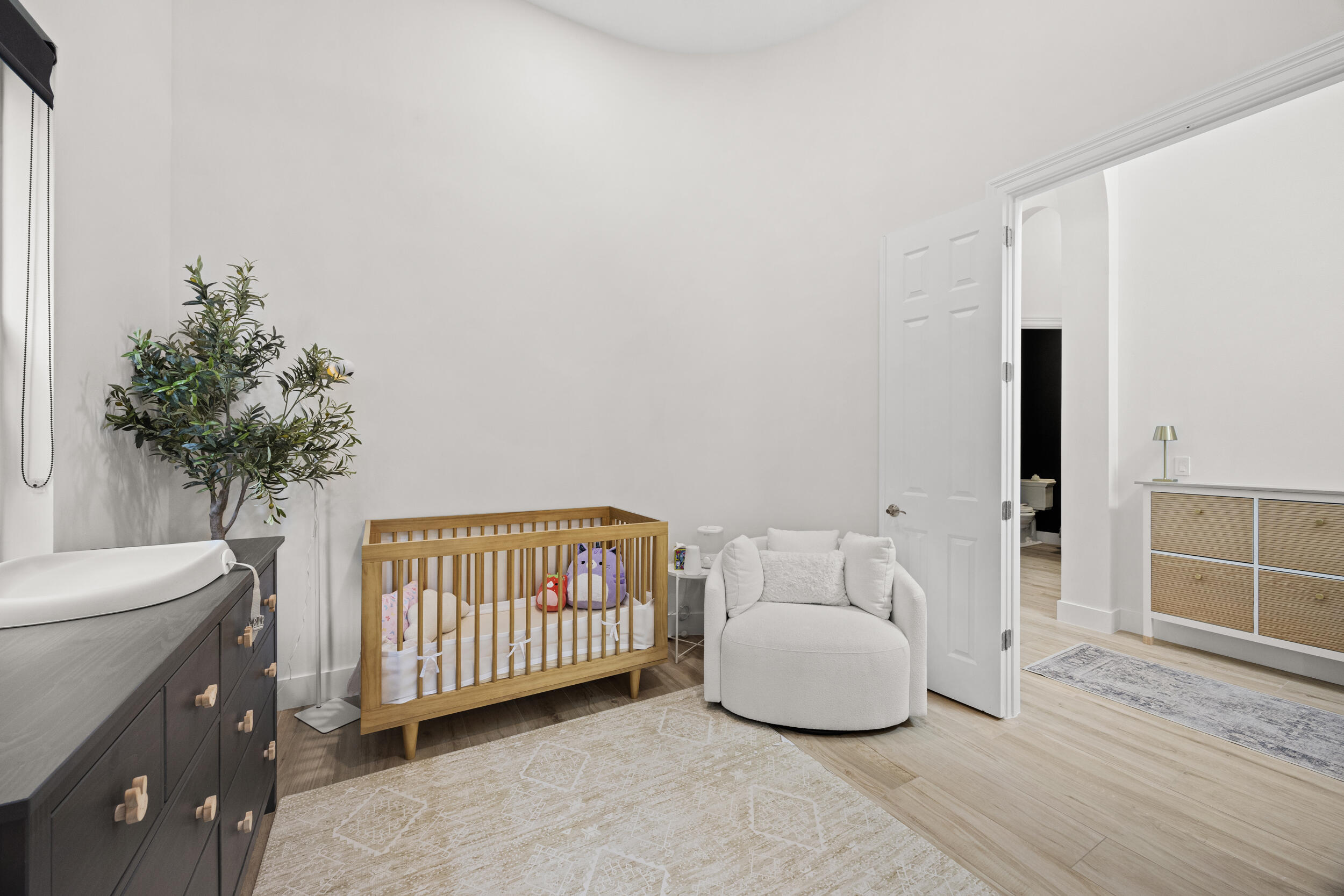 Room featuring high ceilings, wood-finish flooring, and a six-panel door