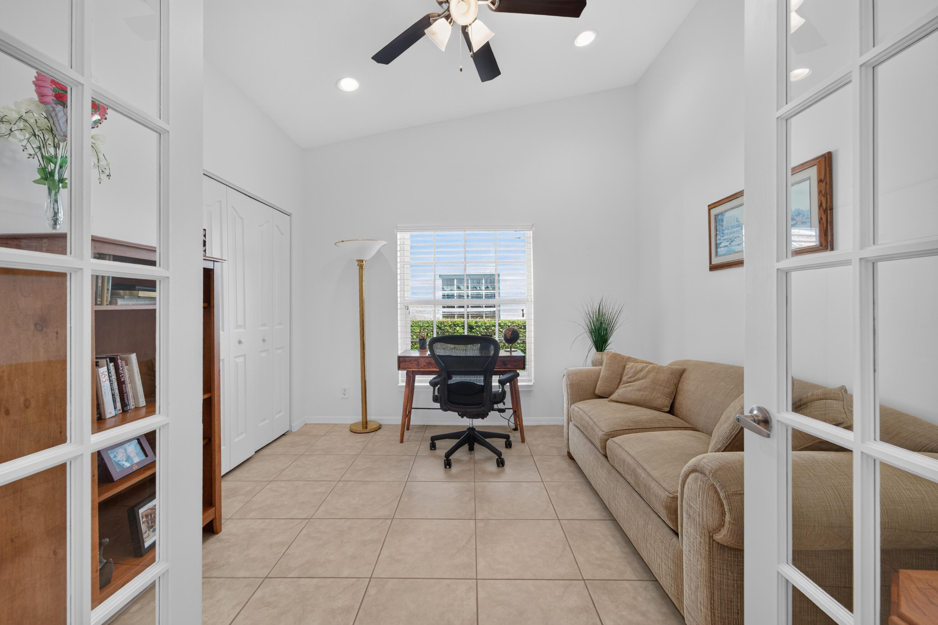 3rd bedroom being used as a office, pull out couch, vaulted ceilings, fan, recess lighting.
