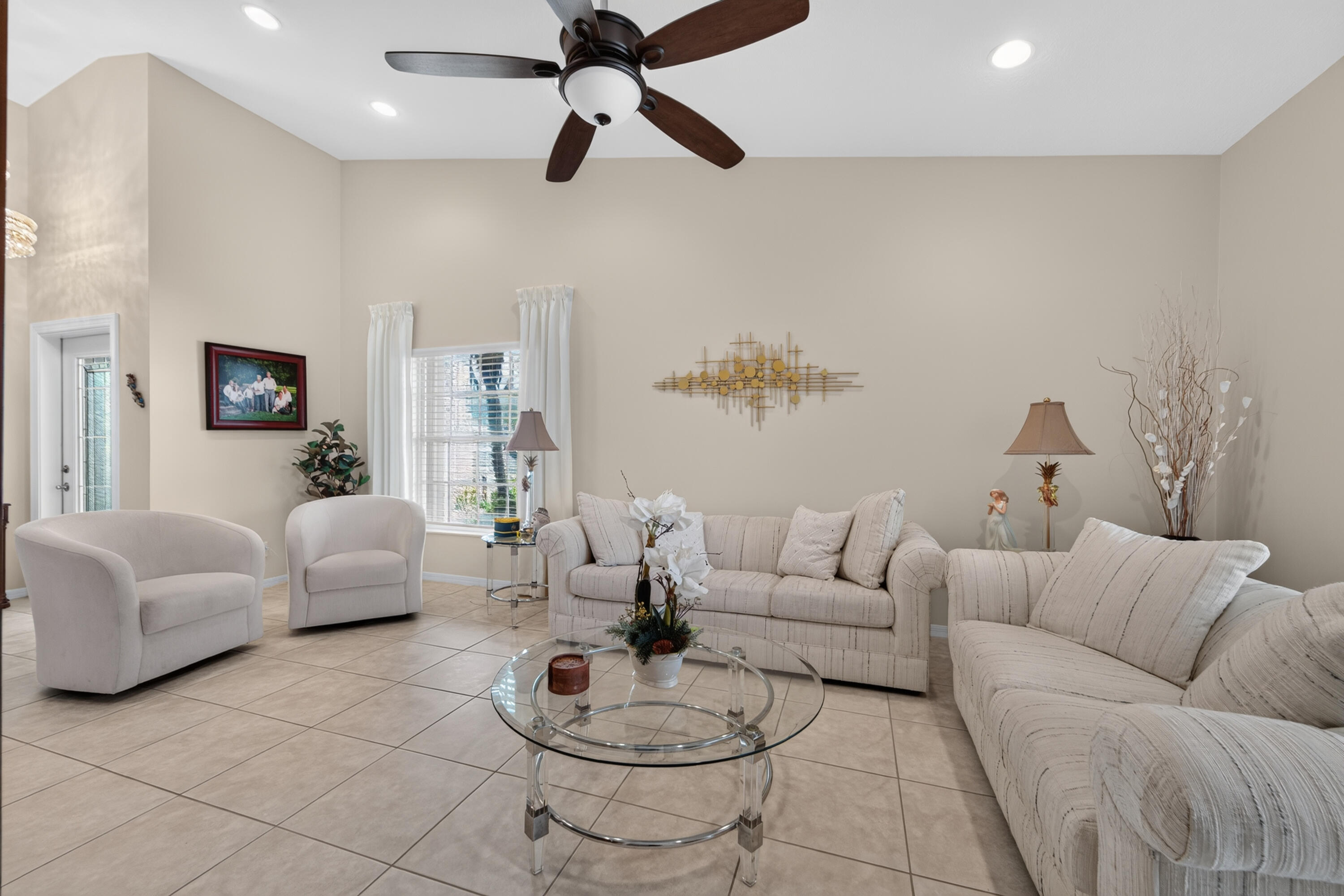 Large Vaulted family room with recess lighting, ceiling fan, blinds and custom drapes.