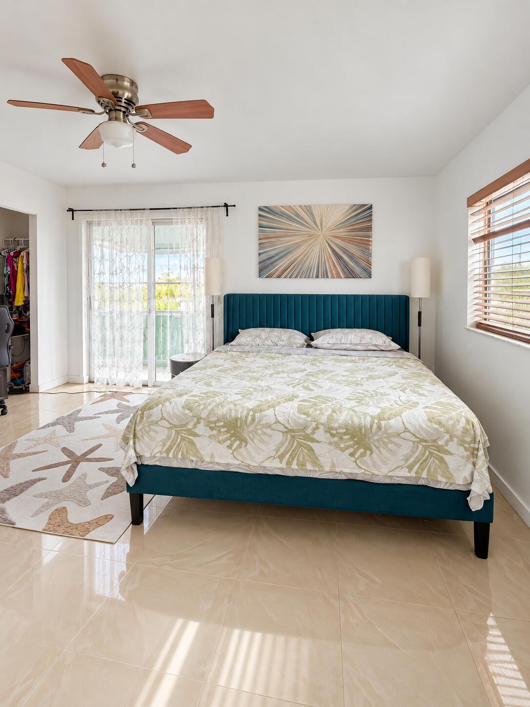 Neutral tile flooring, sliding glass door with exterior access.