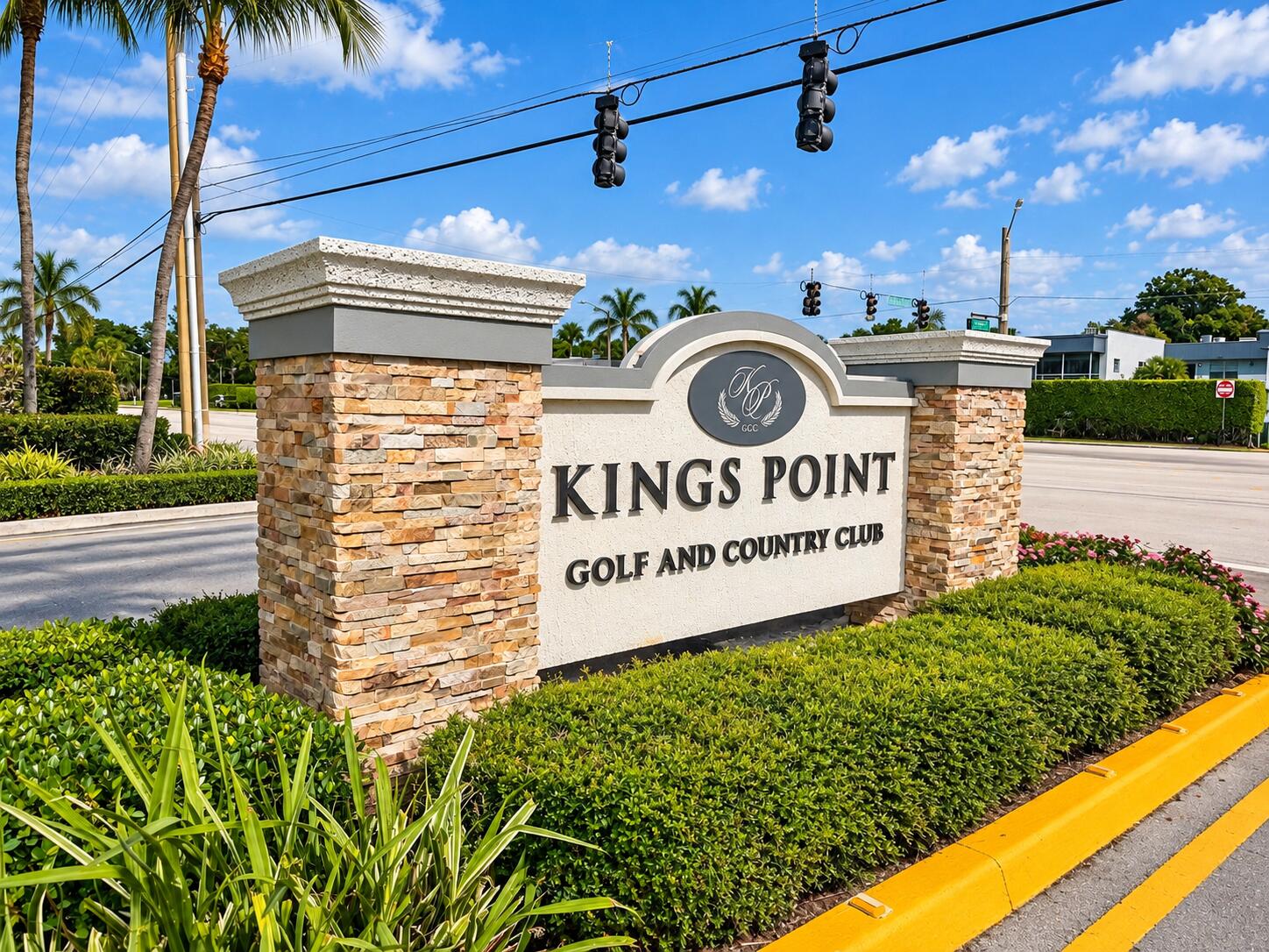 Kings Point Golf and Country Club entrance signage featuring stacked stone masonry columns, molded concrete caps, and professional landscaping