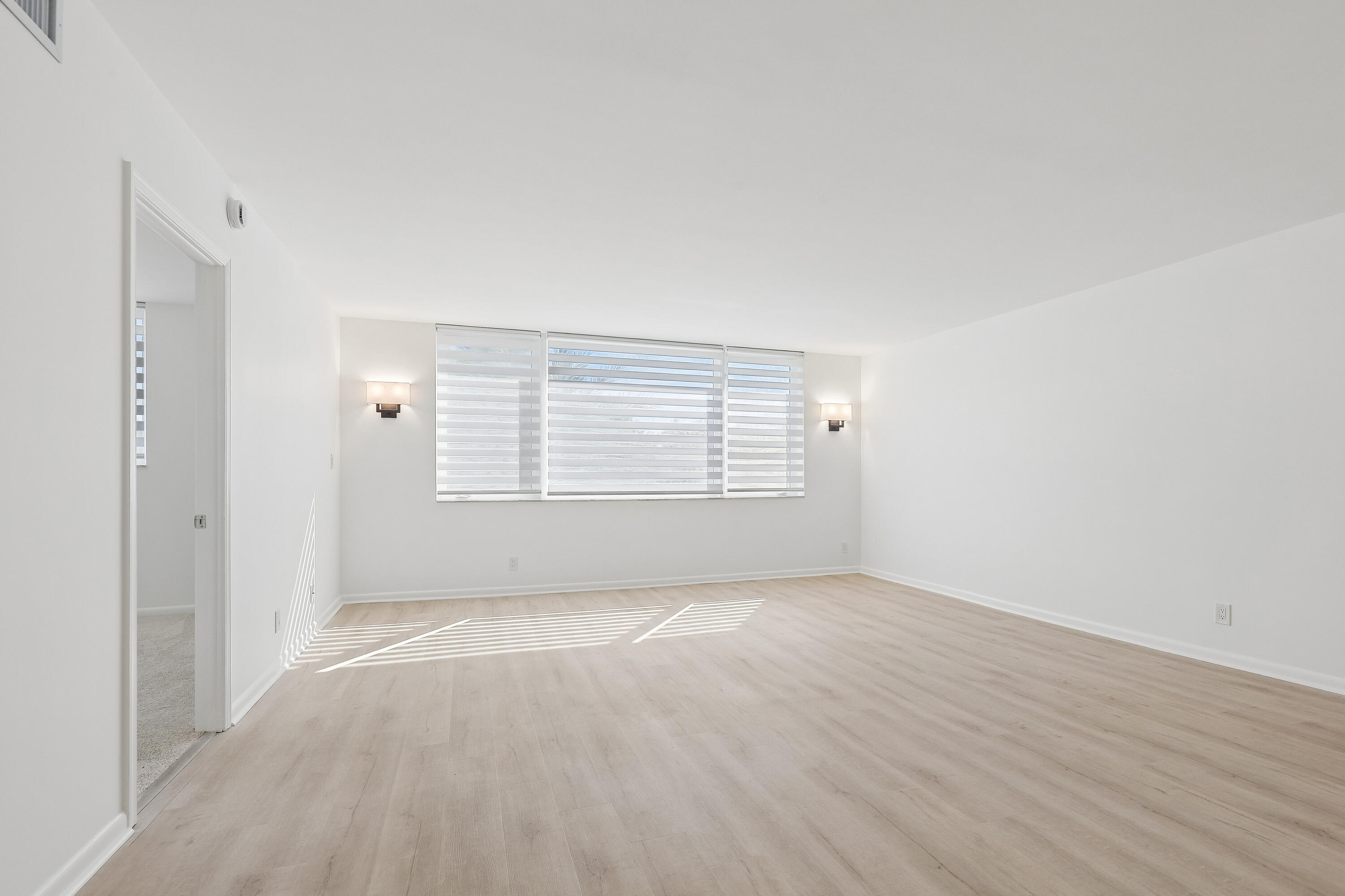 Bright light from the East with Hunter Douglas shades. Classy sconce lighting on wall.