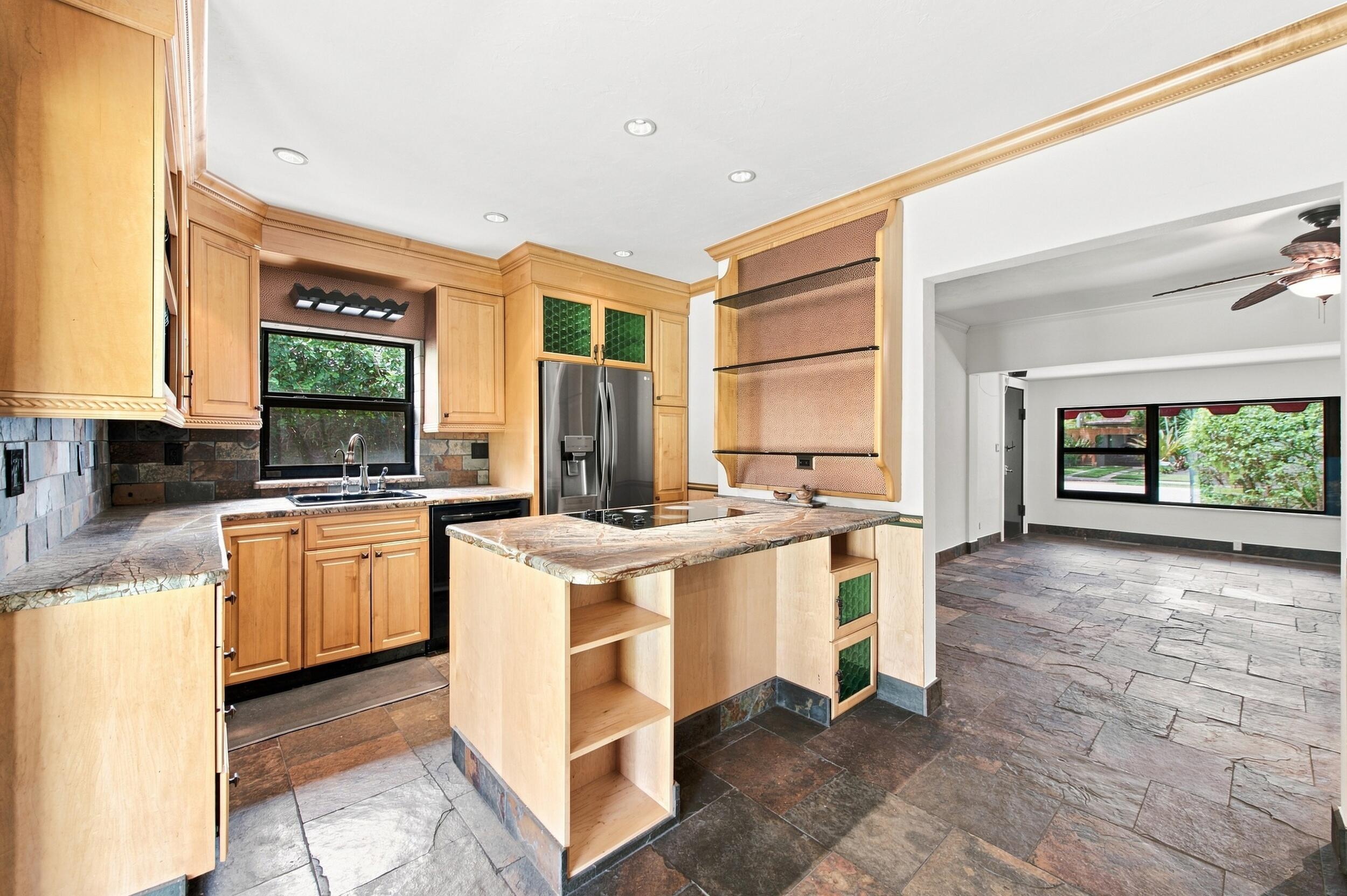 Kitchen featuring natural finish cabinetry, stone-surface countertops, stone tile flooring, built-in open shelving, and recessed lighting