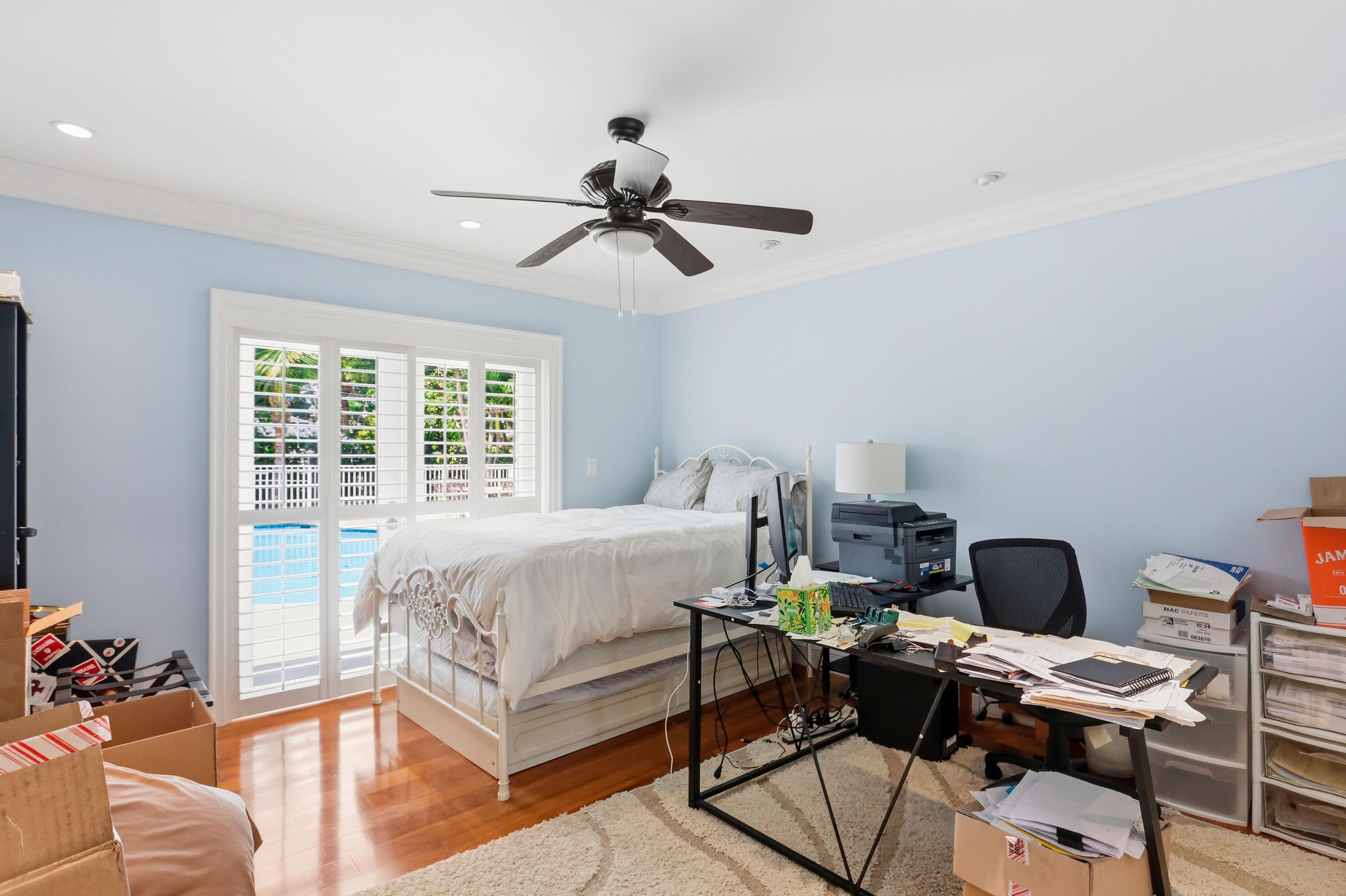 Bedroom featuring wood-finish flooring, crown molding, recessed lighting, a ceiling fan, and sliding glass doors with plantation shutters