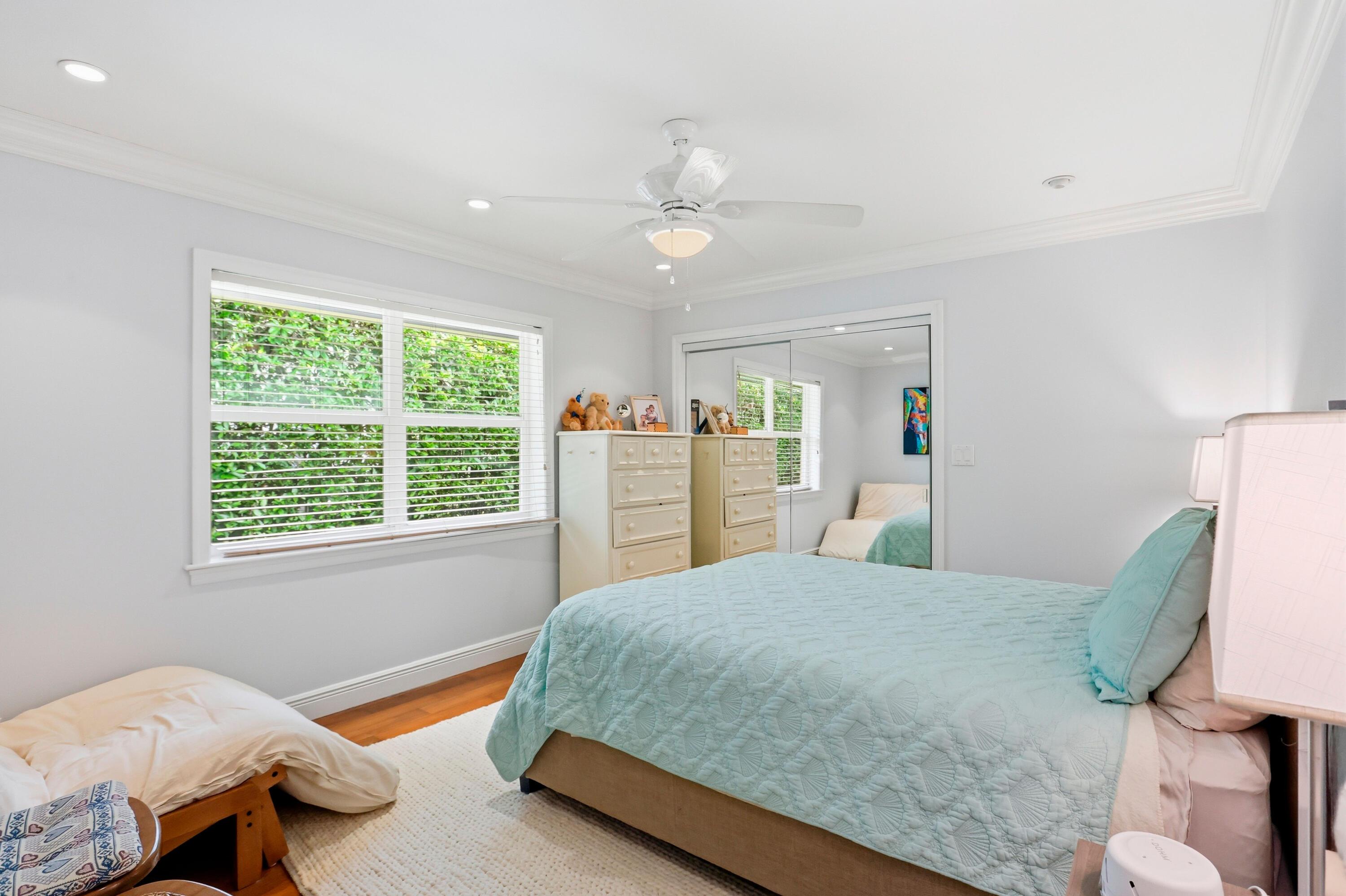 Room featuring wood-finish flooring, crown molding, recessed lighting, a ceiling fan with integrated light, and a double-door mirrored closet