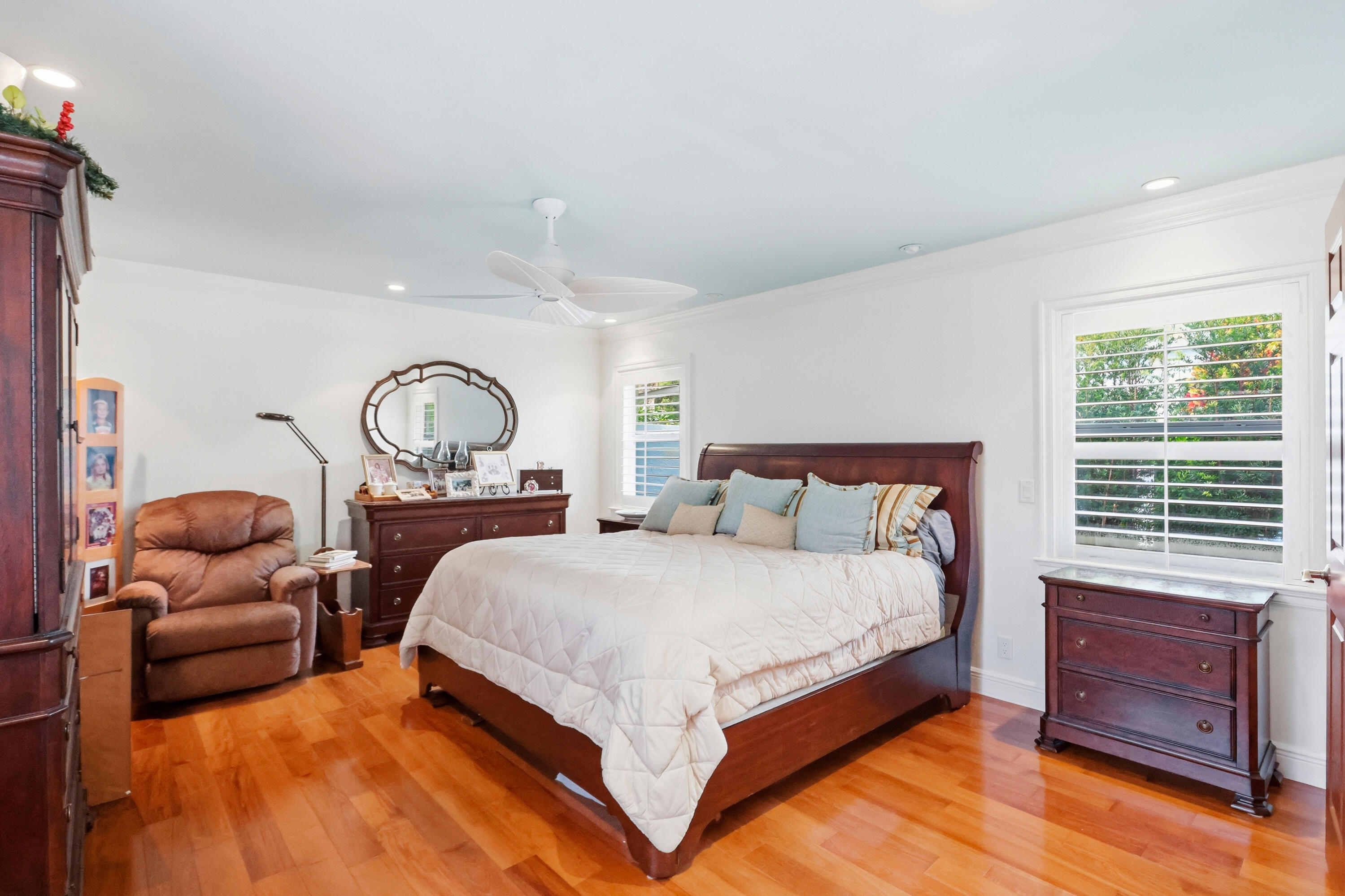 Hardwood flooring, recessed lighting, ceiling fan, and windows equipped with plantation shutters