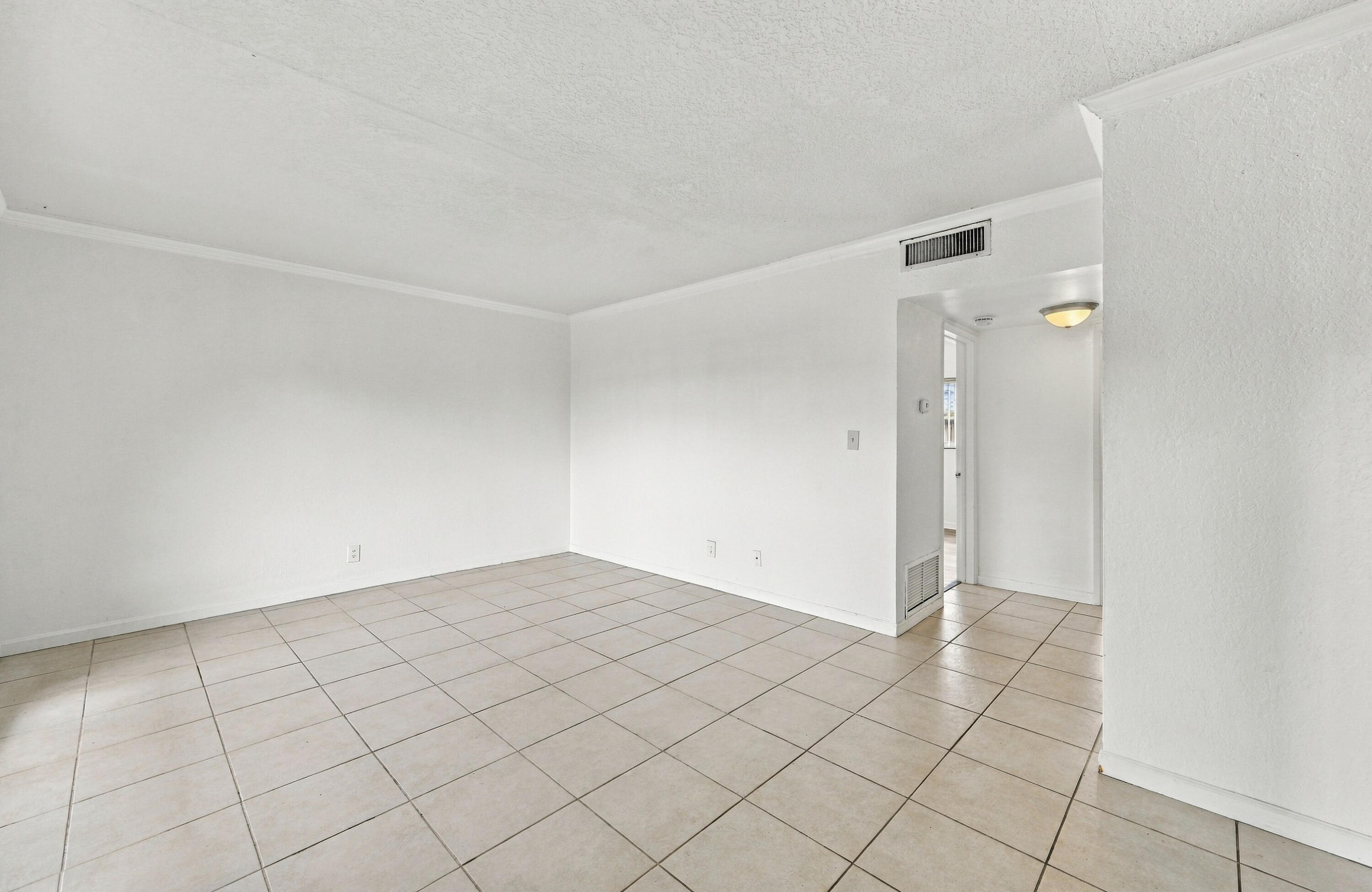 Interior space featuring neutral wall tones, large-format ceramic tile flooring, and a flush-mount overhead light fixture