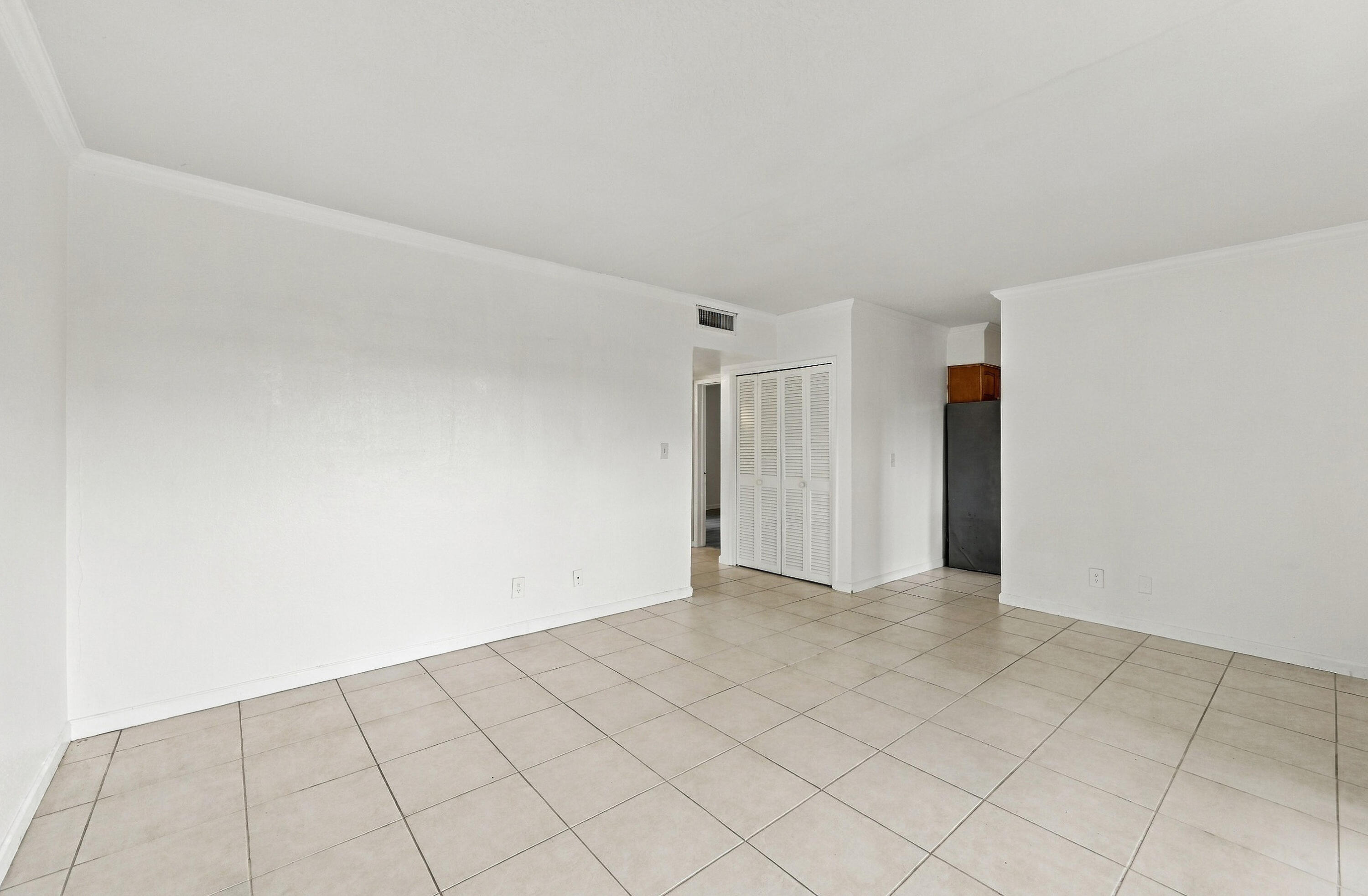 Neutral-toned tile flooring, white wall finishes, and bi-fold closet doors