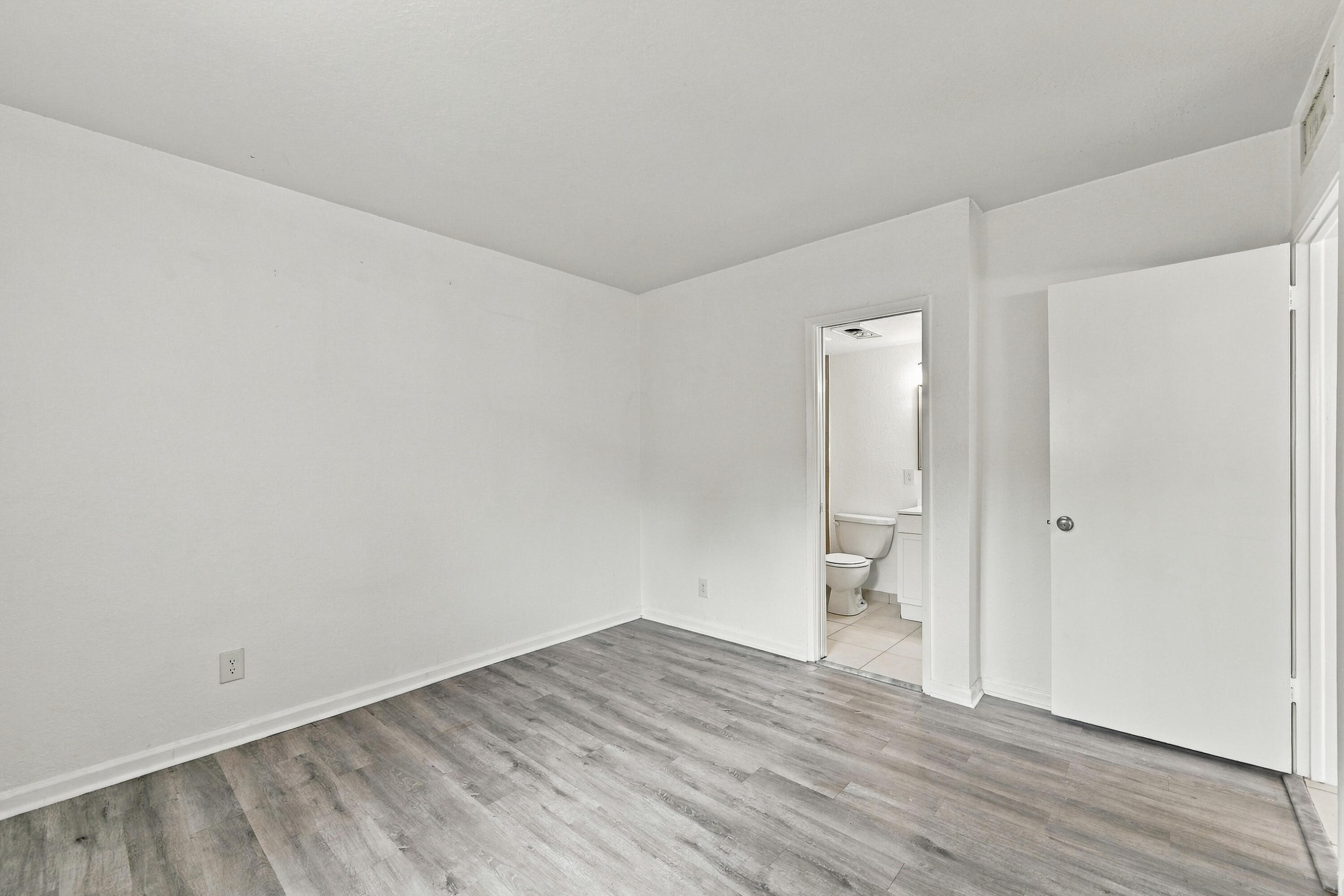 Interior space featuring wood-finish flooring, white walls, and a solid-core interior door