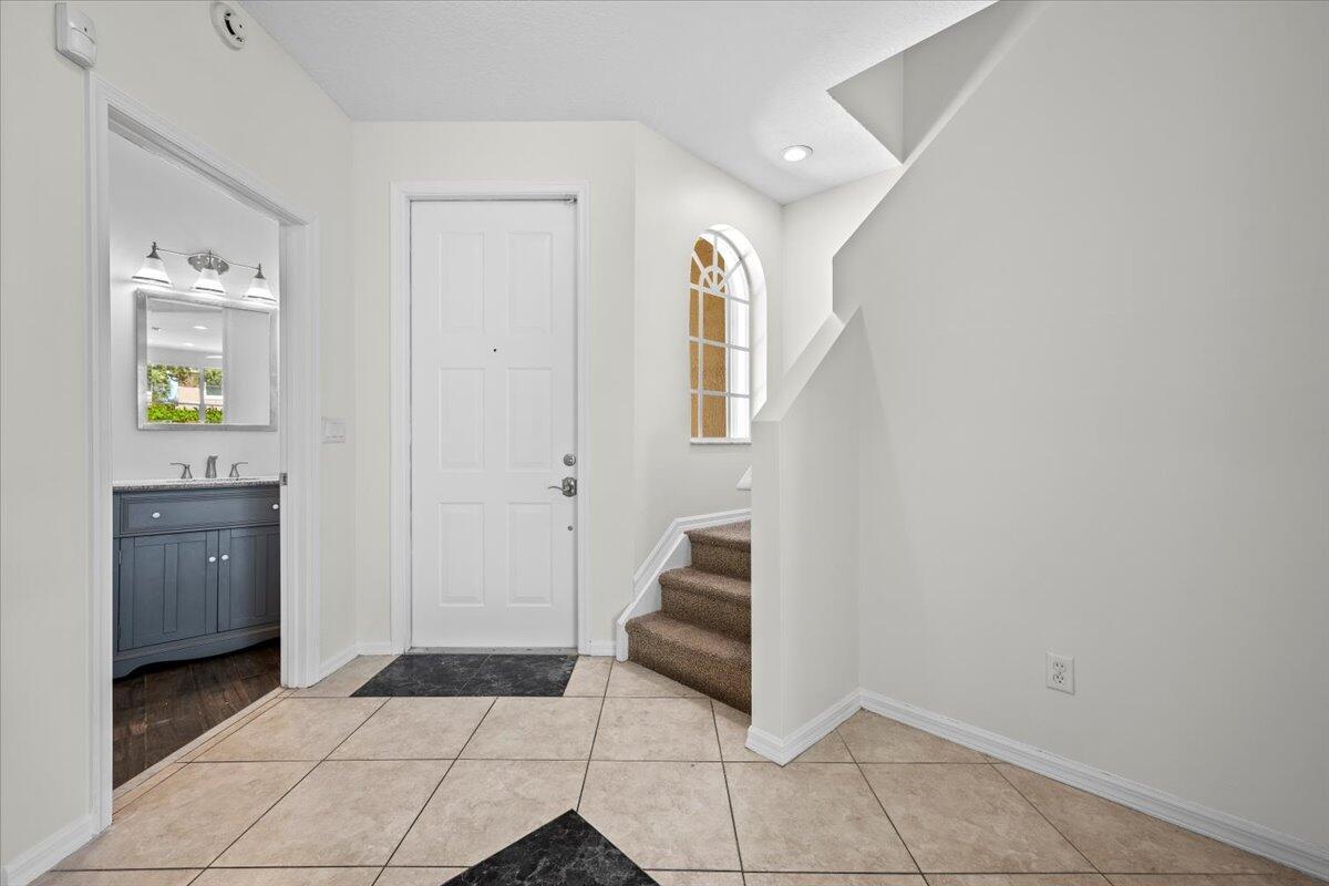 Bright entryway with tile flooring, staircase, and access to the kitchen. Bright entryway with tile flooring, staircase, and access to the kitchen.