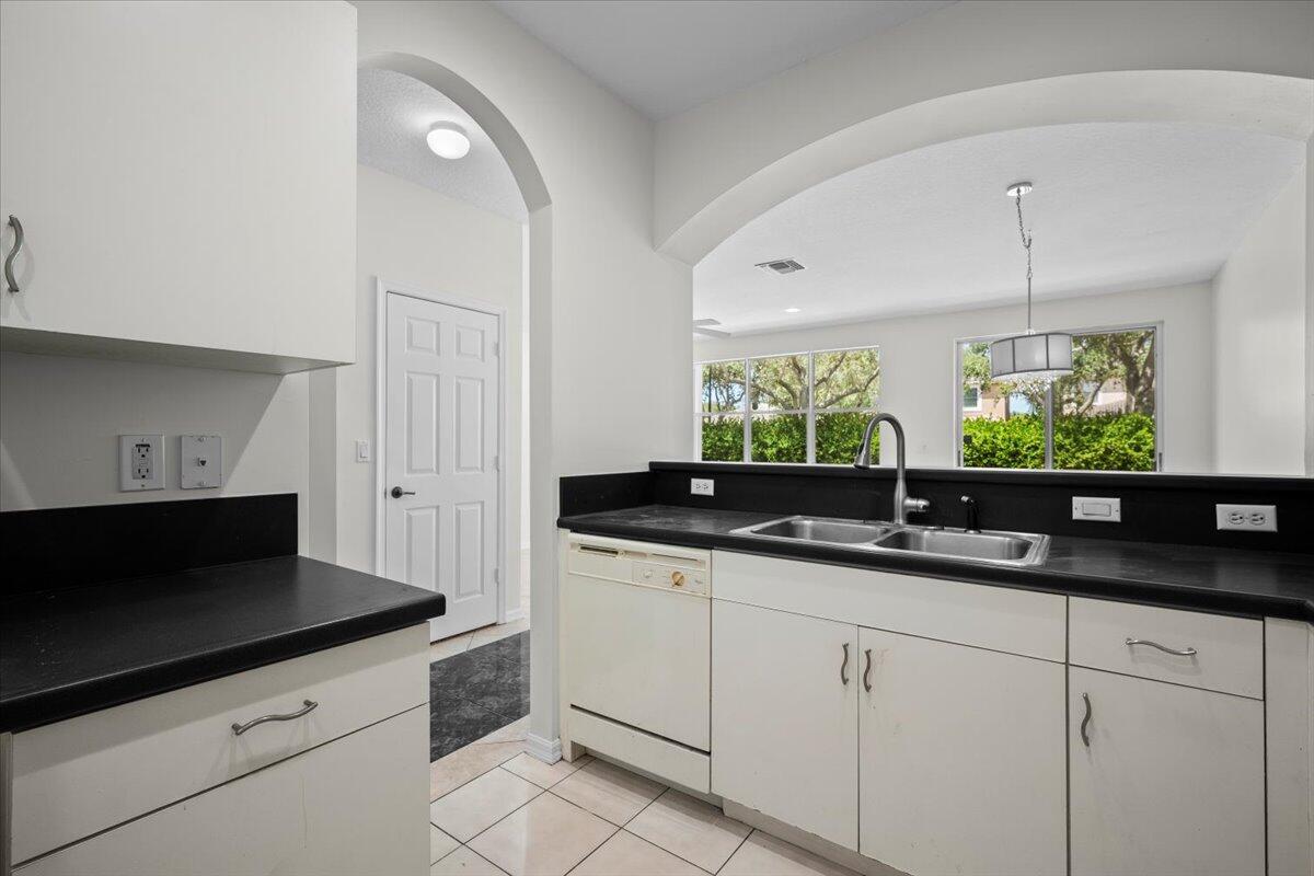 Additional view highlighting the countertop space, cabinetry, and arched opening to the living area. Additional view highlighting the countertop space, cabinetry, and arched opening to the living area.