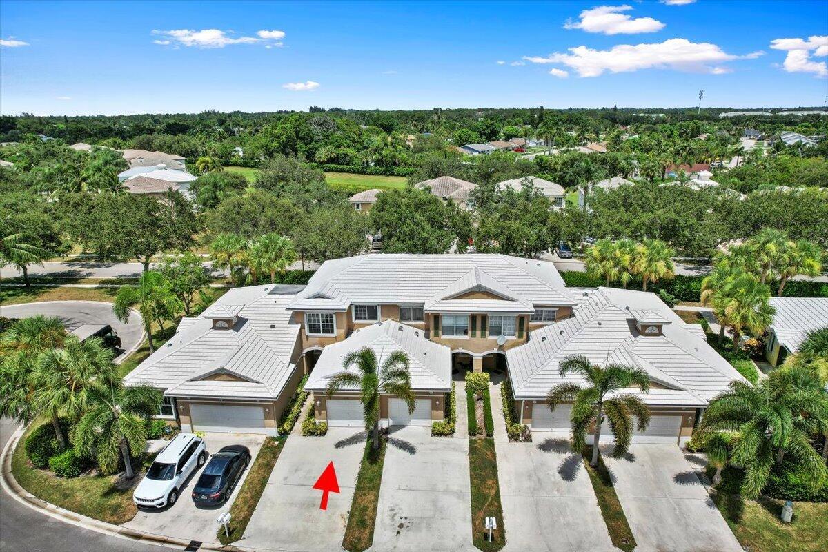 Front aerial view showcasing the townhome, driveway, and surrounding neighborhood.