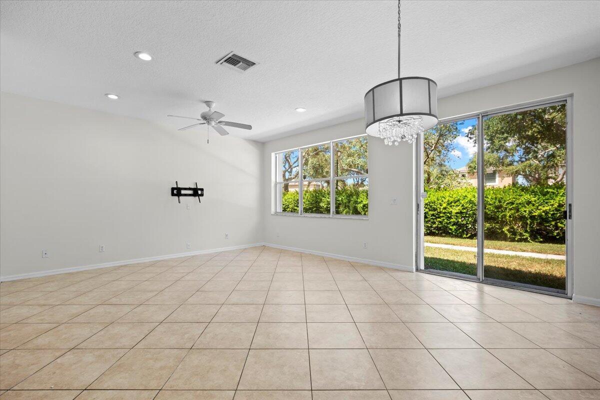 Spacious, open living area with tile flooring, natural light, and sliding glass doors. Spacious, open living area with tile flooring, natural light, and sliding glass doors.