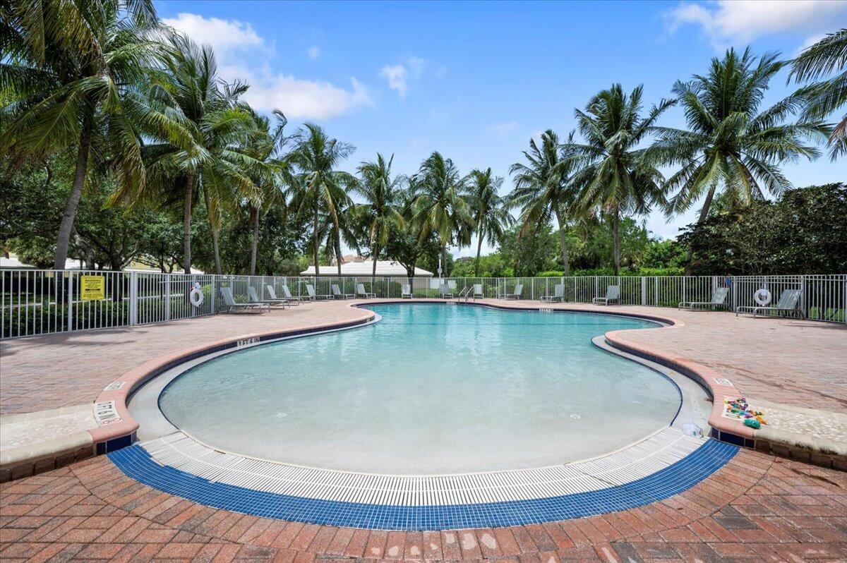 Enjoy the community swimming pool surrounded by palm trees and a spacious pool deck.