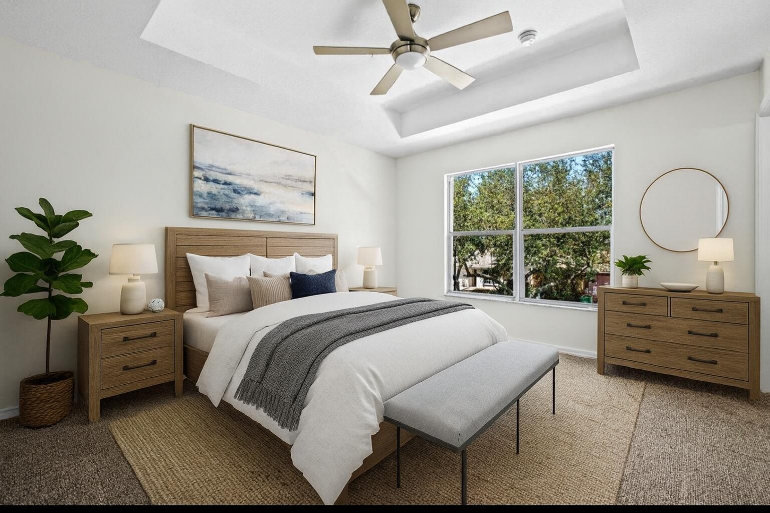 Virtually staged primary suite showcasing the tray ceiling, generous floor space, and relaxing atmosphere.