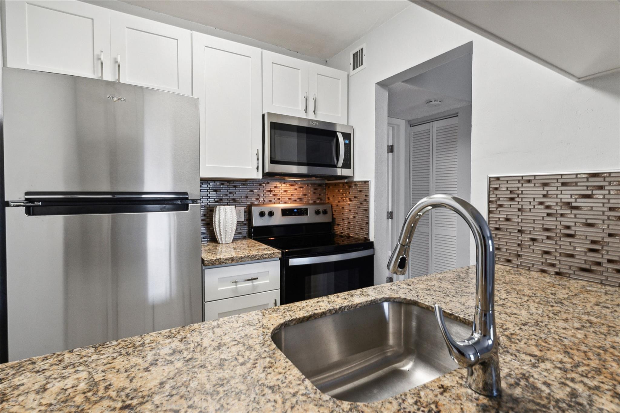 New cabinets, marble counters tile backsplash and stainless appliances