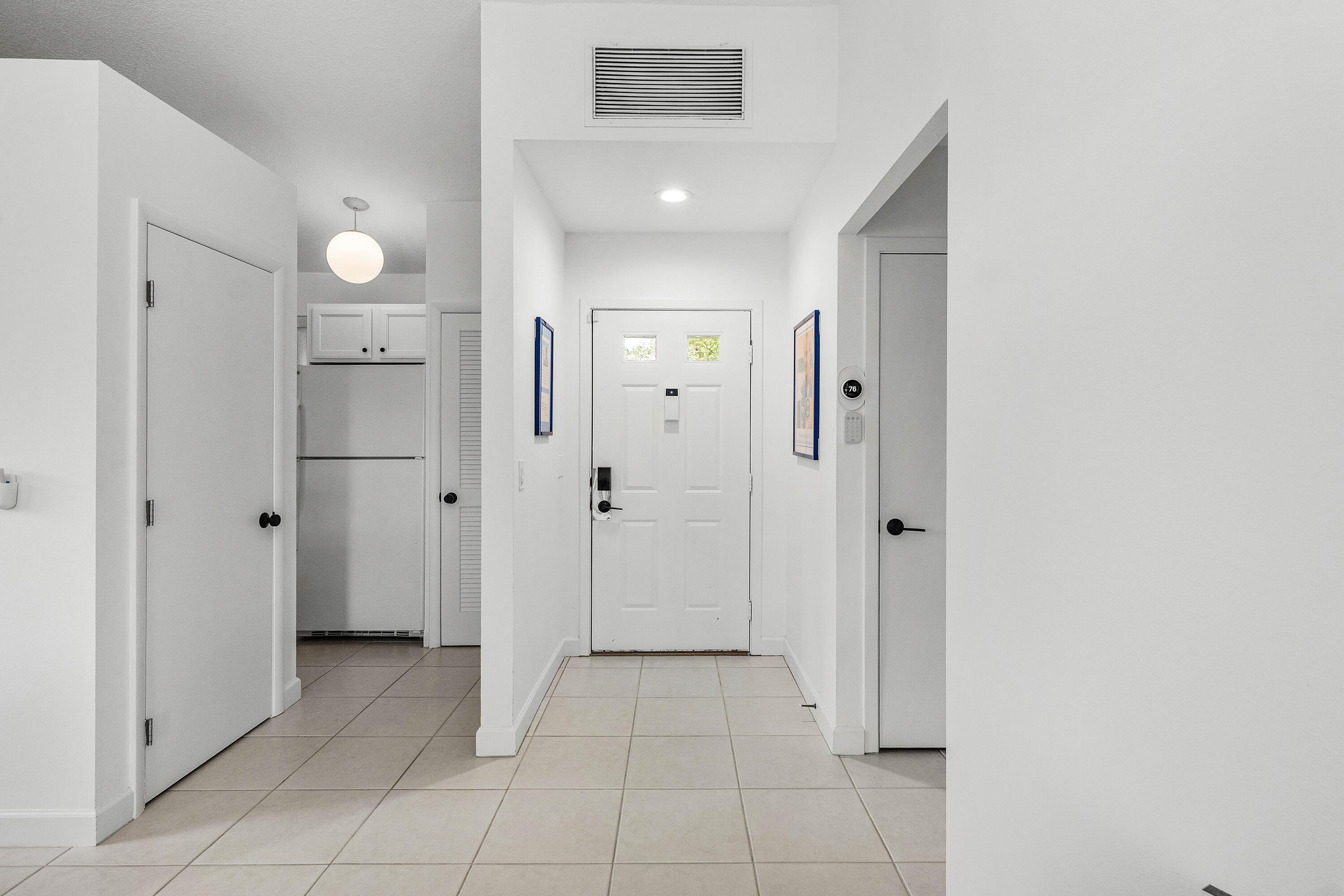 Entryway featuring neutral tile flooring, a six-panel front door with dual glass inserts, and recessed ceiling lighting