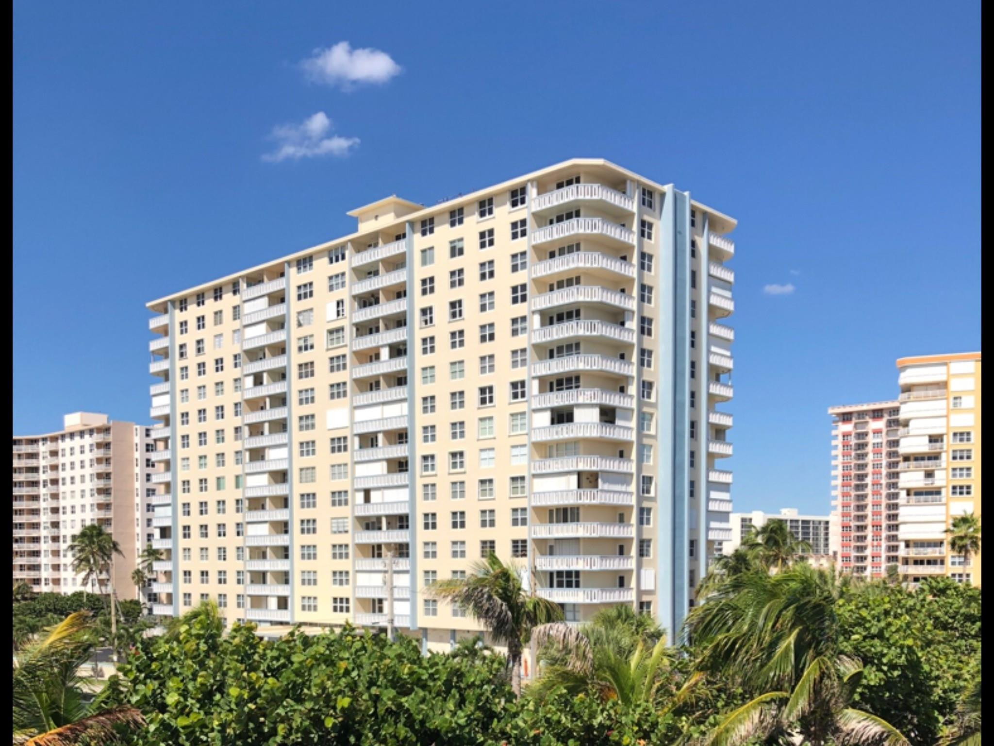 High-rise residential exterior featuring wrap-around balconies, a structured facade, and integrated railings
