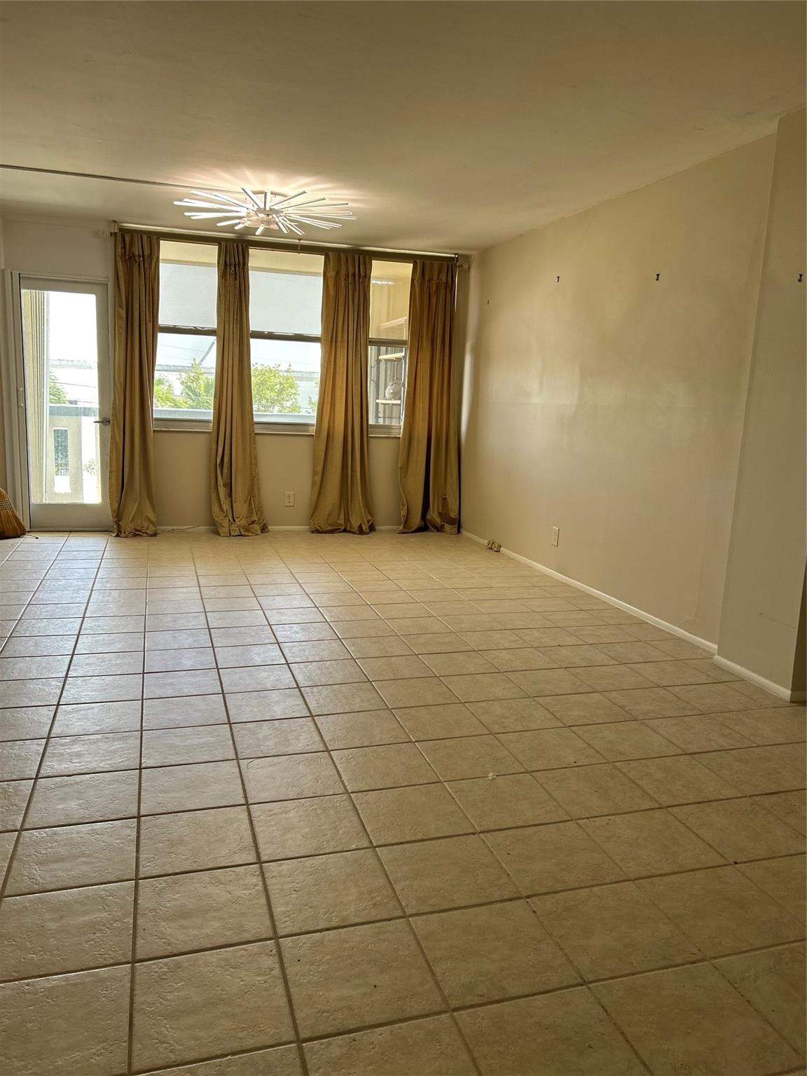 Large ceramic tile flooring, oversized picture windows, and a glass-paneled exterior door