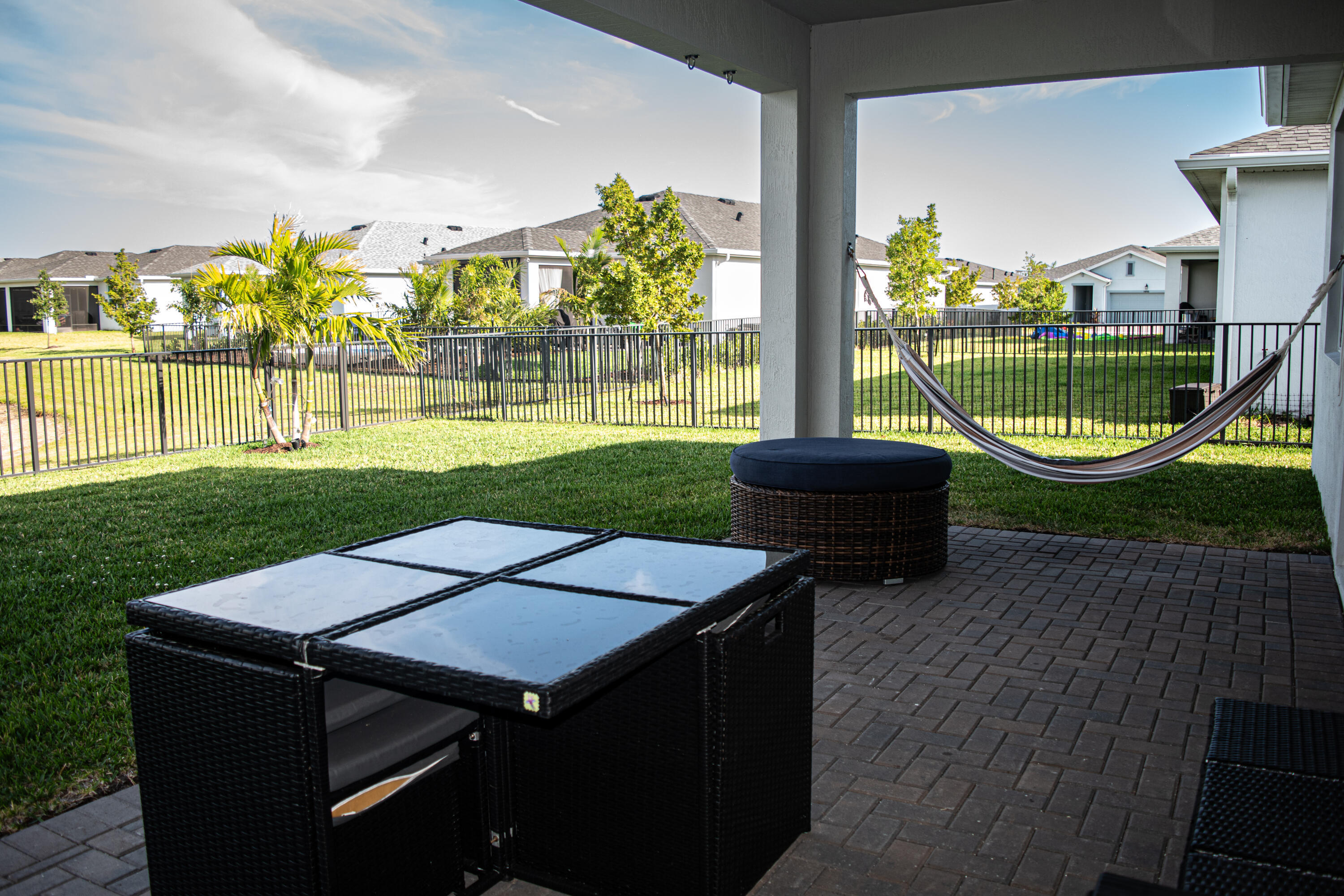 Covered patio featuring a paver surface, fenced backyard, and lawn area