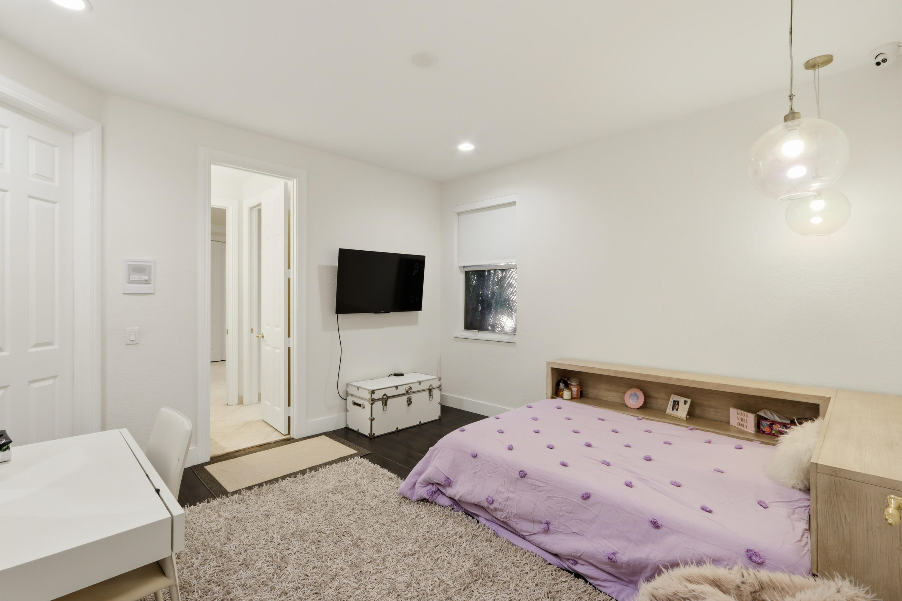 Room featuring wood-finish flooring, recessed lighting, and a dual-pendant glass light fixture