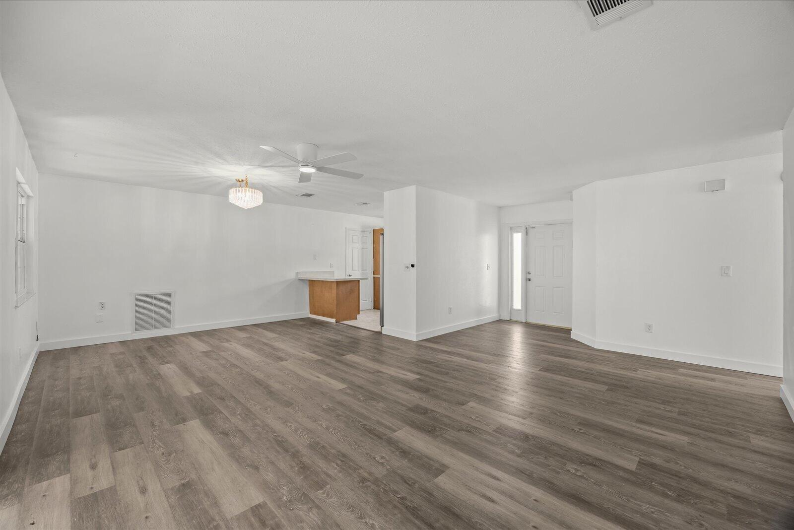 Open living area featuring wood-finish flooring, recessed lighting, a ceiling fan, and a neutral color palette