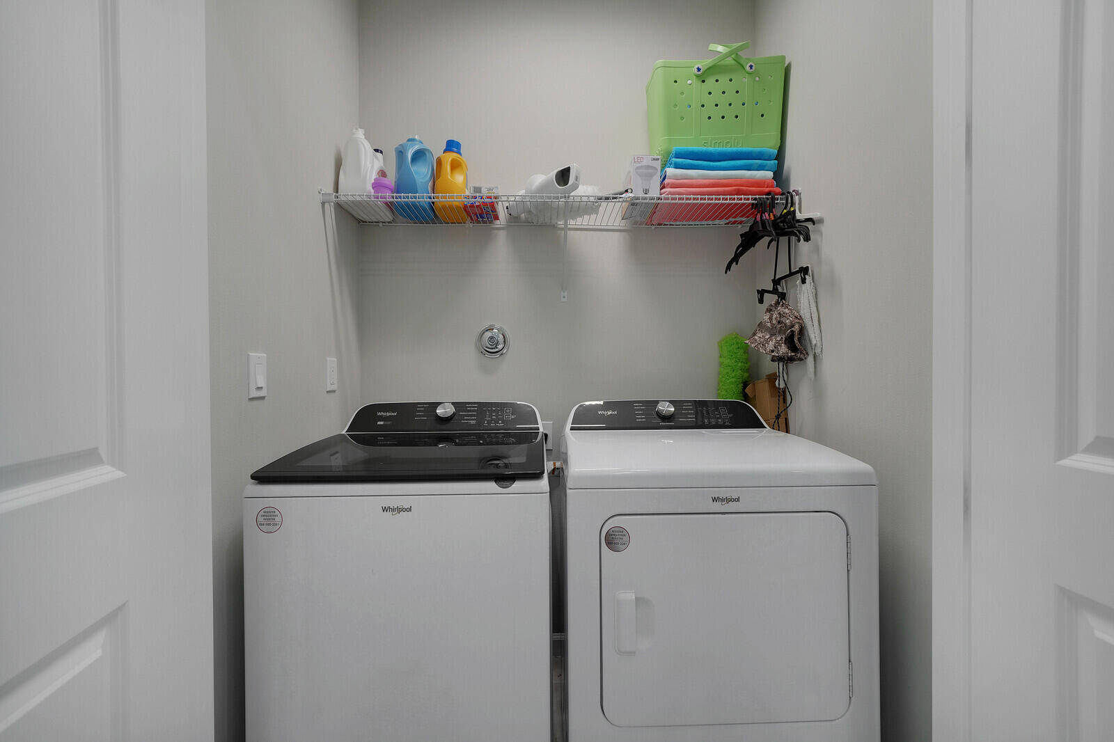 Convenient 1st Floor Laundry closet featuring built-in wire shelving and dual-door entry