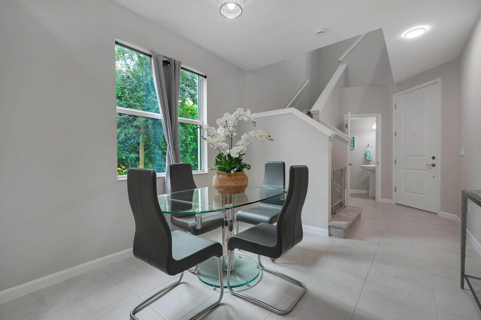 Neutral interior space featuring large window, recessed lighting, tile flooring, and a multi-panel door