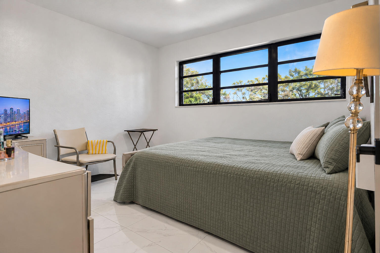 Neutral interior space featuring polished tile flooring, smooth wall finishes, and large horizontal-pane windows with black frames