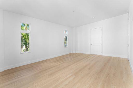 Light-filled room featuring wood-finish flooring, recessed lighting, and white interior doors