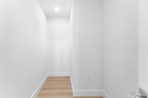 Enclosed space featuring wood-finish flooring, neutral wall finishes, and recessed ceiling lighting