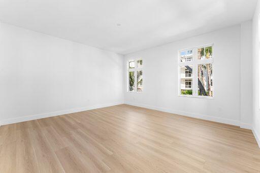 Interior space featuring wood-finish flooring, white walls, and multi-pane windows