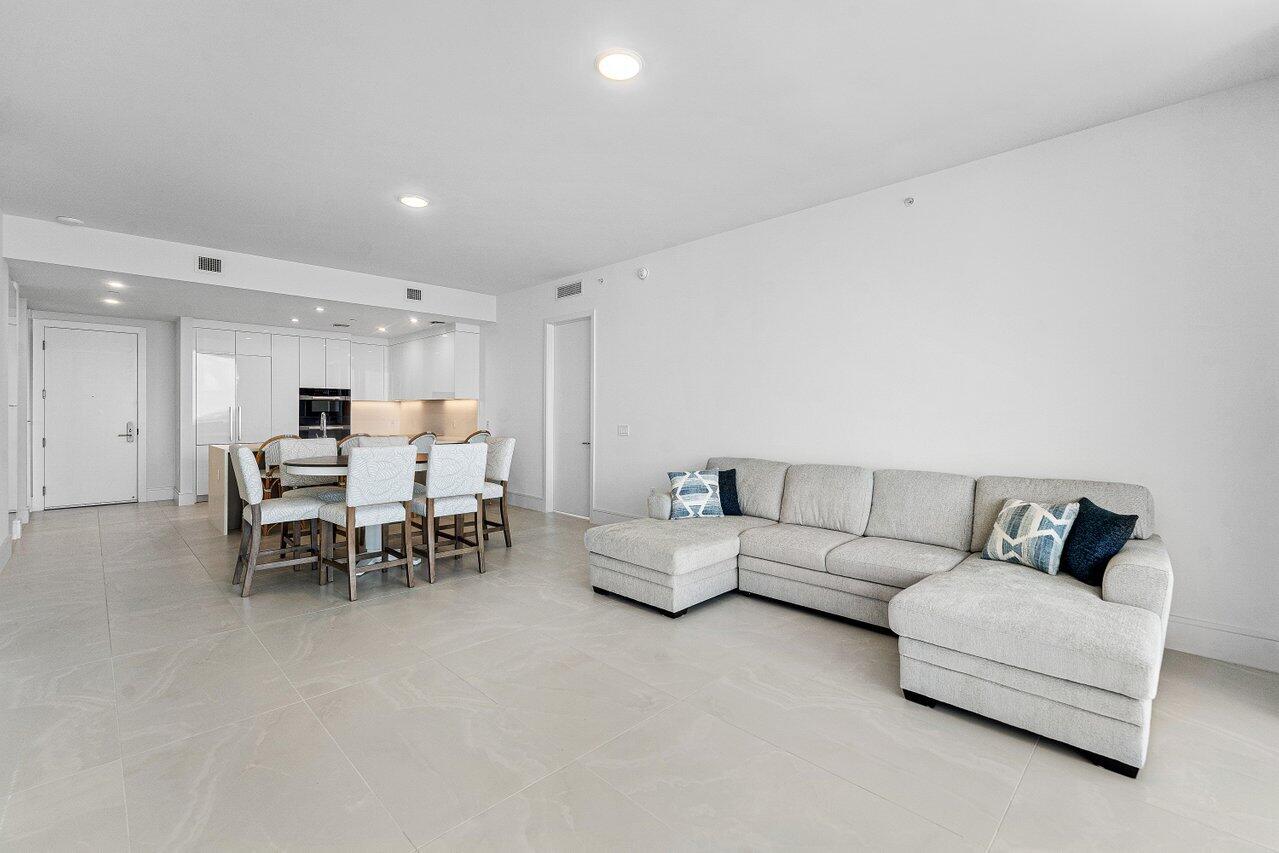 Open-concept interior featuring large-format tile flooring, recessed ceiling lighting, and minimalist flat-panel cabinetry