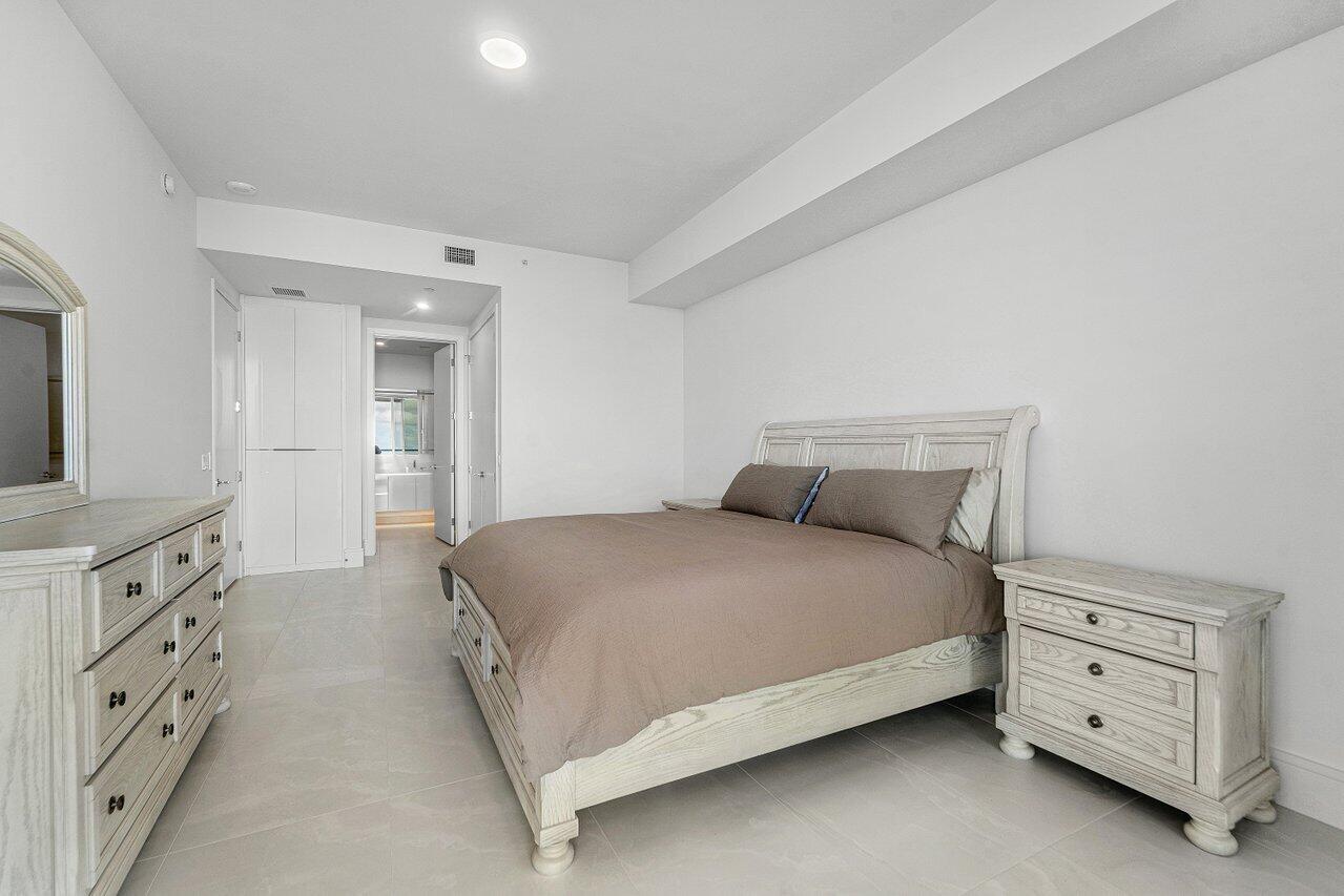 Interior space featuring neutral stone-finish tile flooring, recessed ceiling lighting, and floor-to-ceiling built-in cabinetry