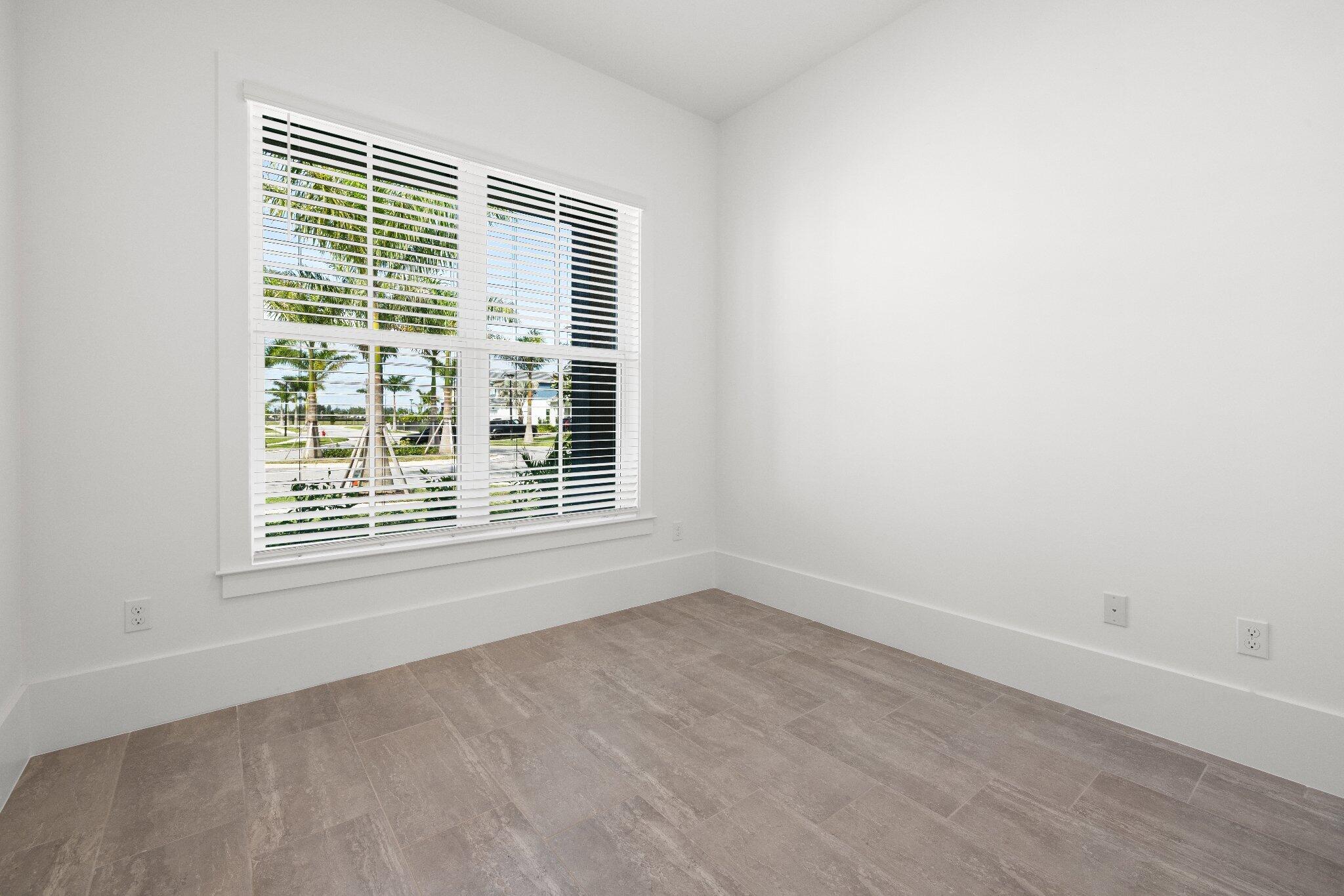 Neutral-toned tile flooring, large multi-pane window, and crisp white wall finishes