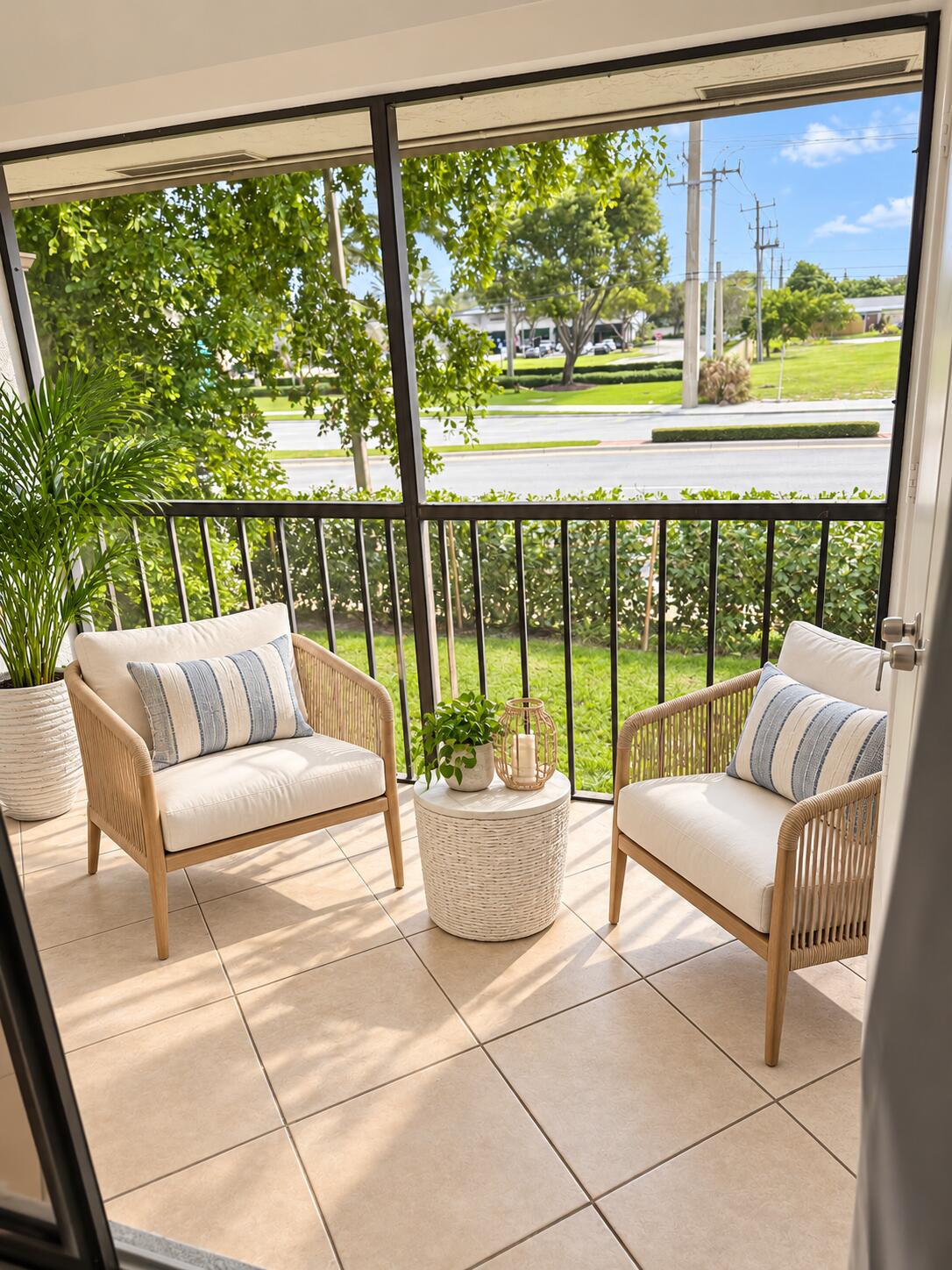 Screened-in balcony with tiled flooring and black metal railing