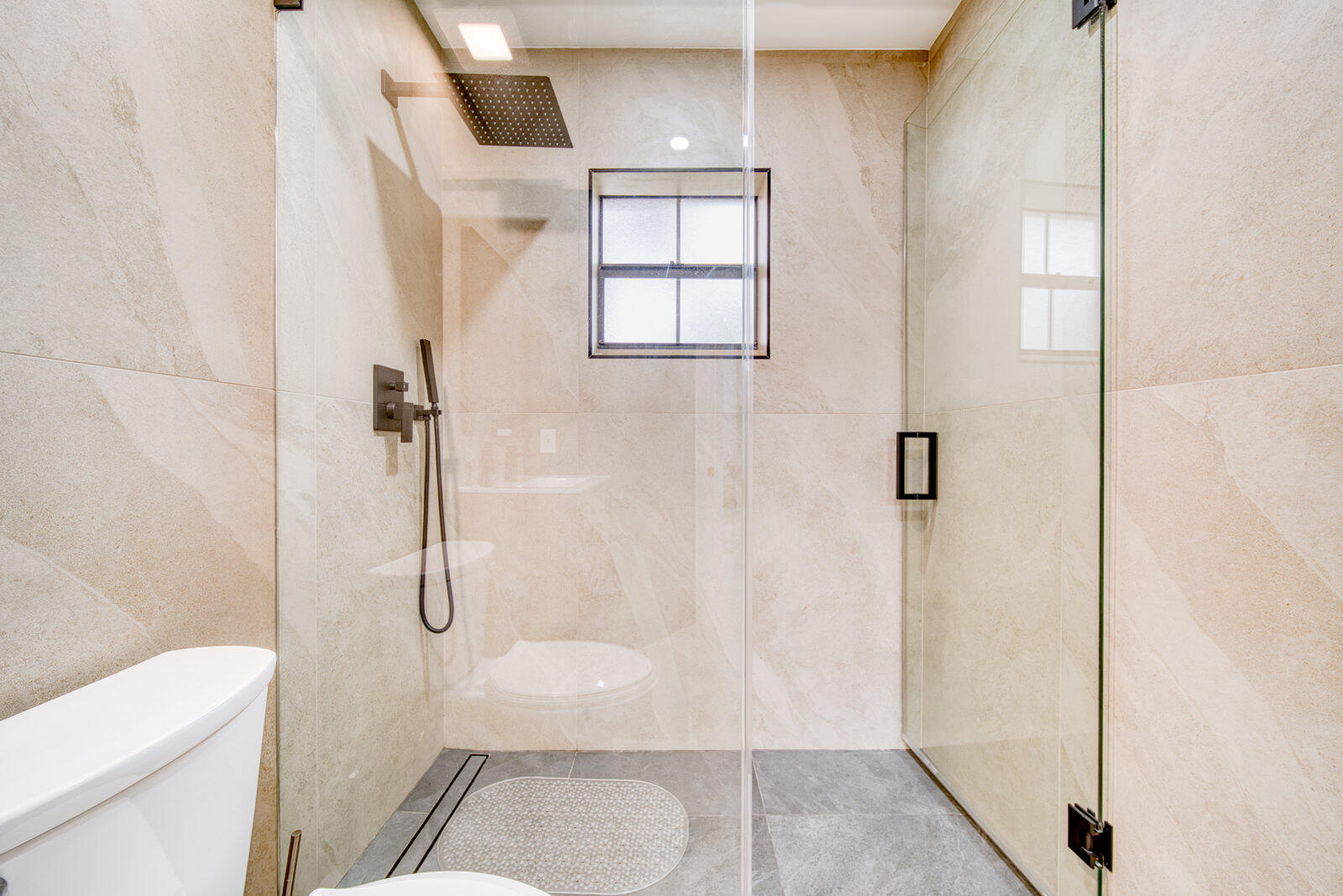 Gray and beige porcelain tile with matte black hardware.