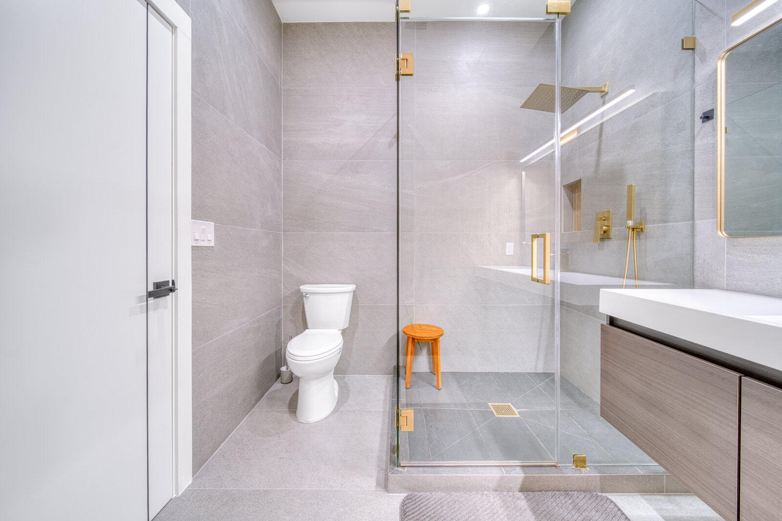 Oversized glass-enclosed shower with floor-to-ceiling tile.