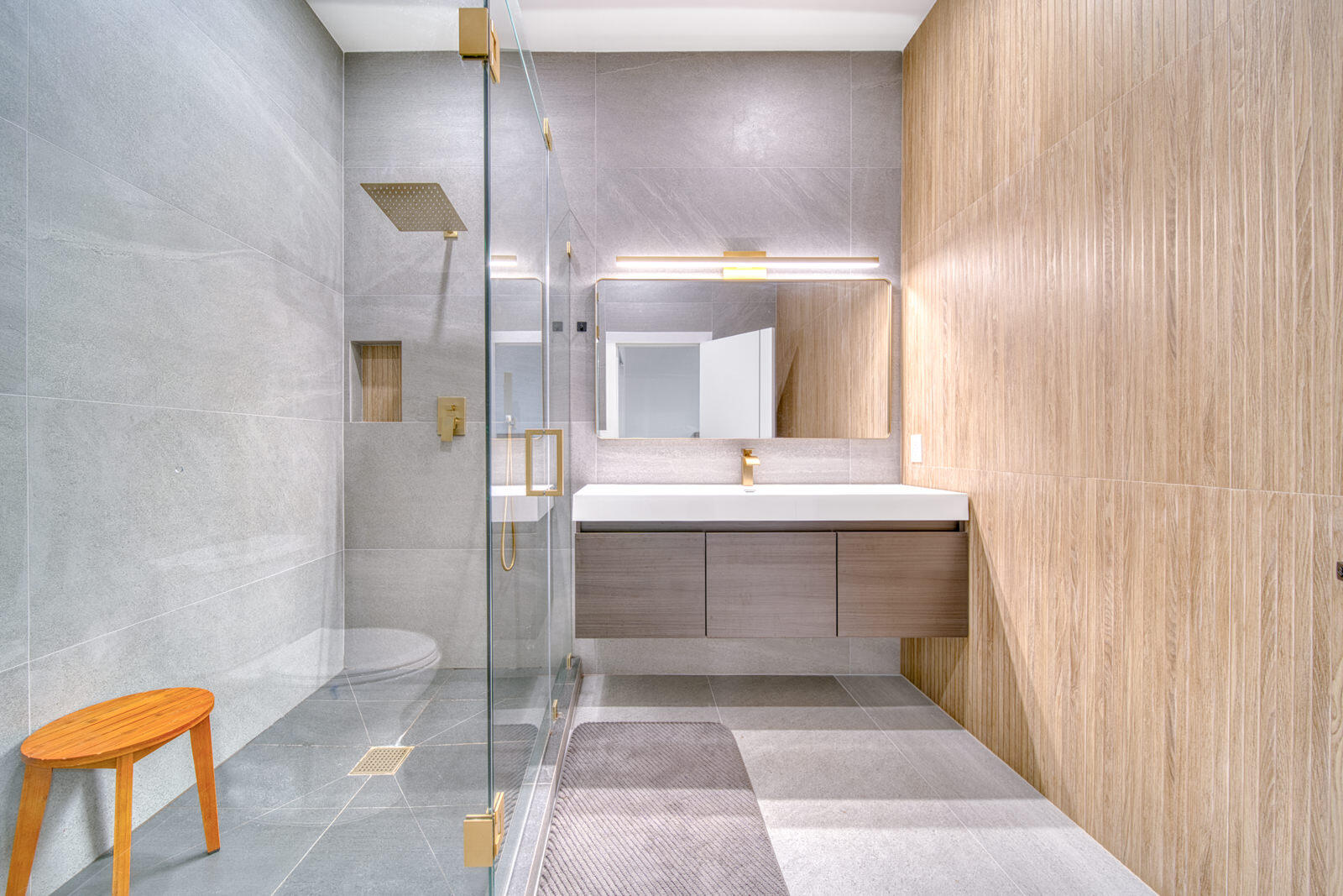 Limestone- and oak-look porcelain tile with gold-tone hardware.