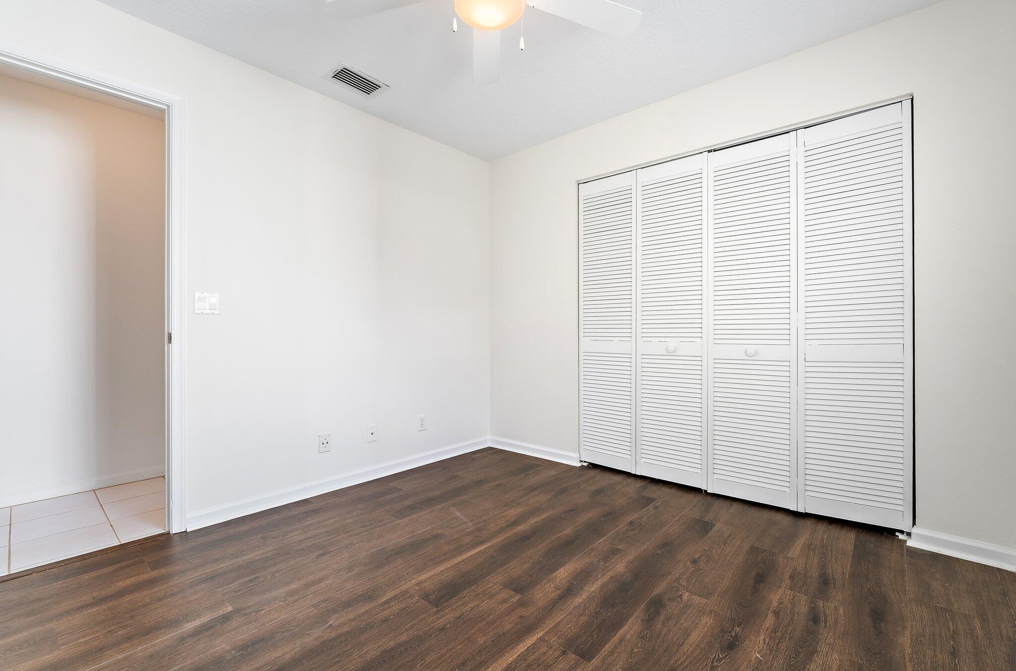 Guest bedroom with a double closet and natural light.