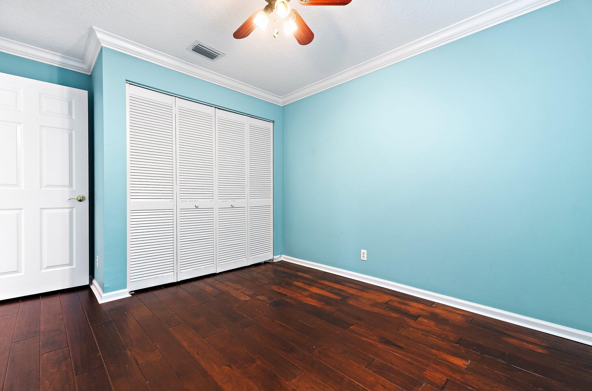 Guest bedroom with wood floors and a double closet.
